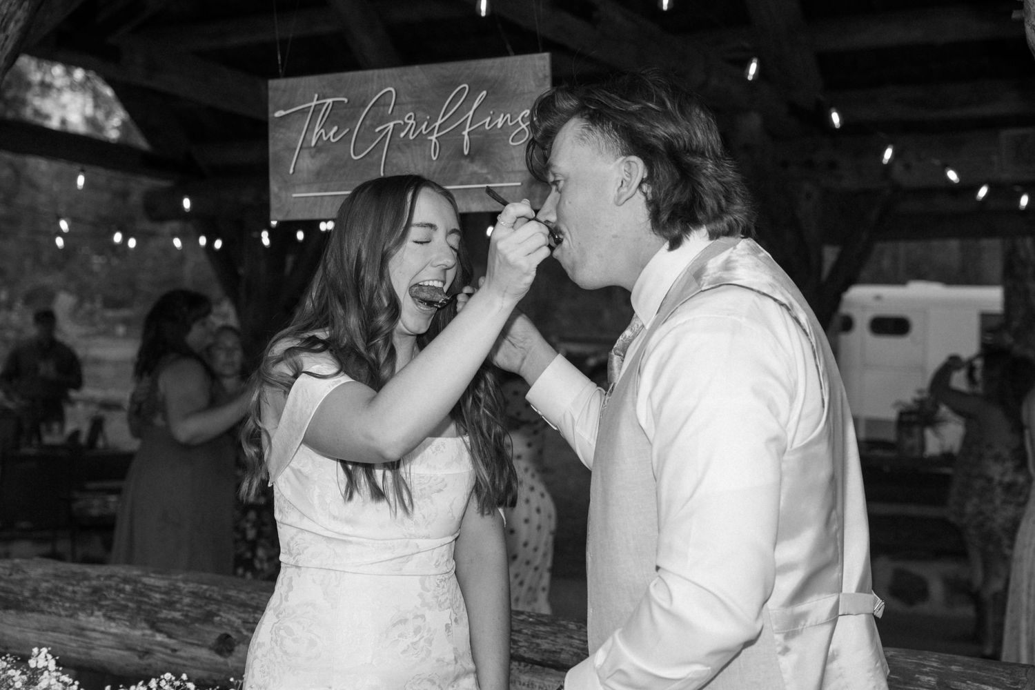 Black and white photo of a romantic moment at a rustic barn wedding reception.