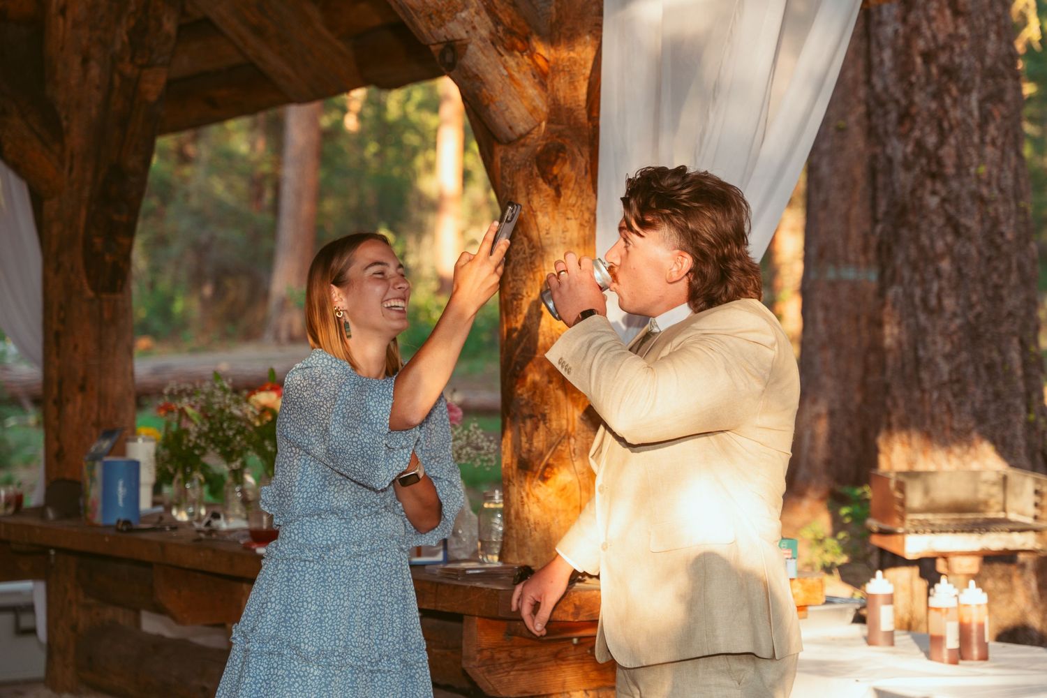 Couples dancing at a rustic outdoor wedding venue with string lights and natural surroundings.