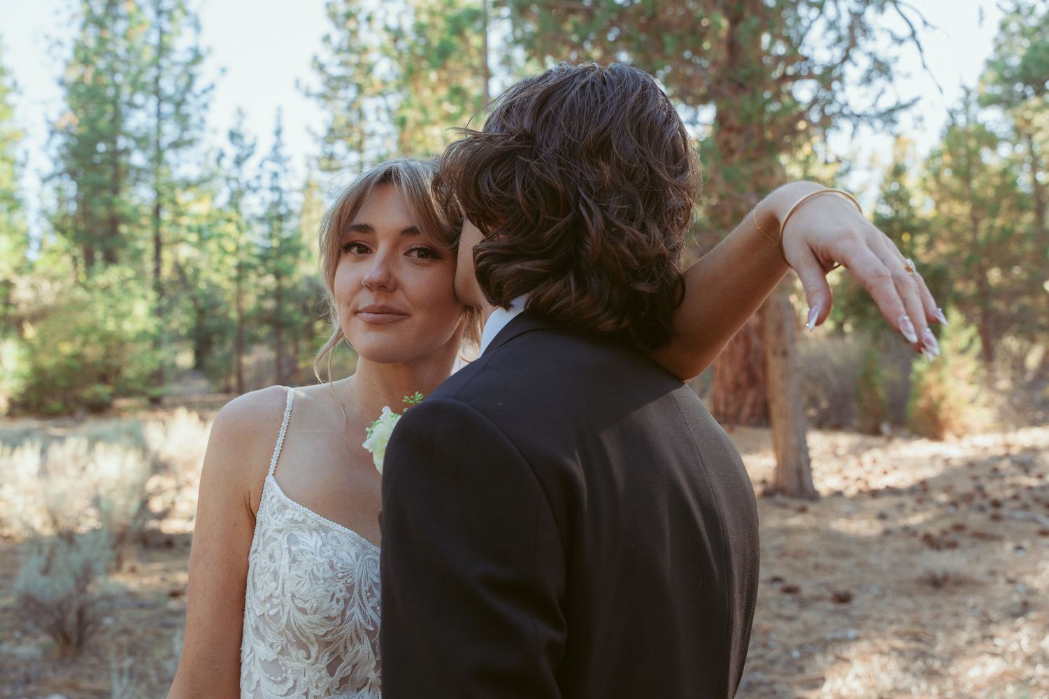 Candid wedding photography capturing a joyful moment in a wooded setting.