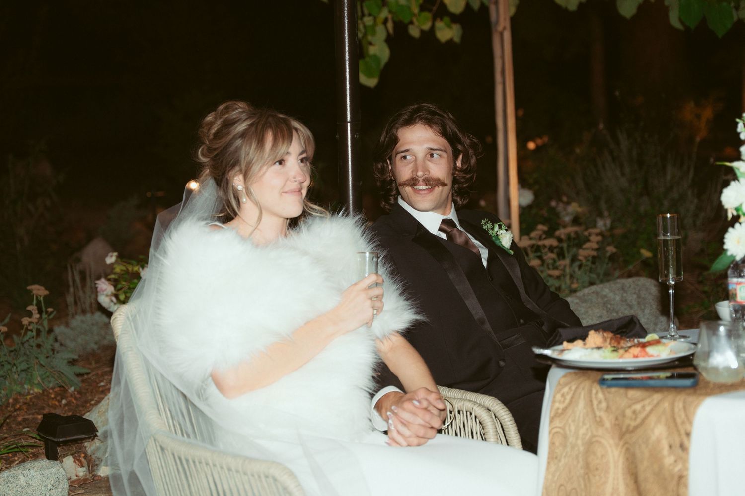 Wedding reception moment captured with white floral decorations and soft evening lighting.