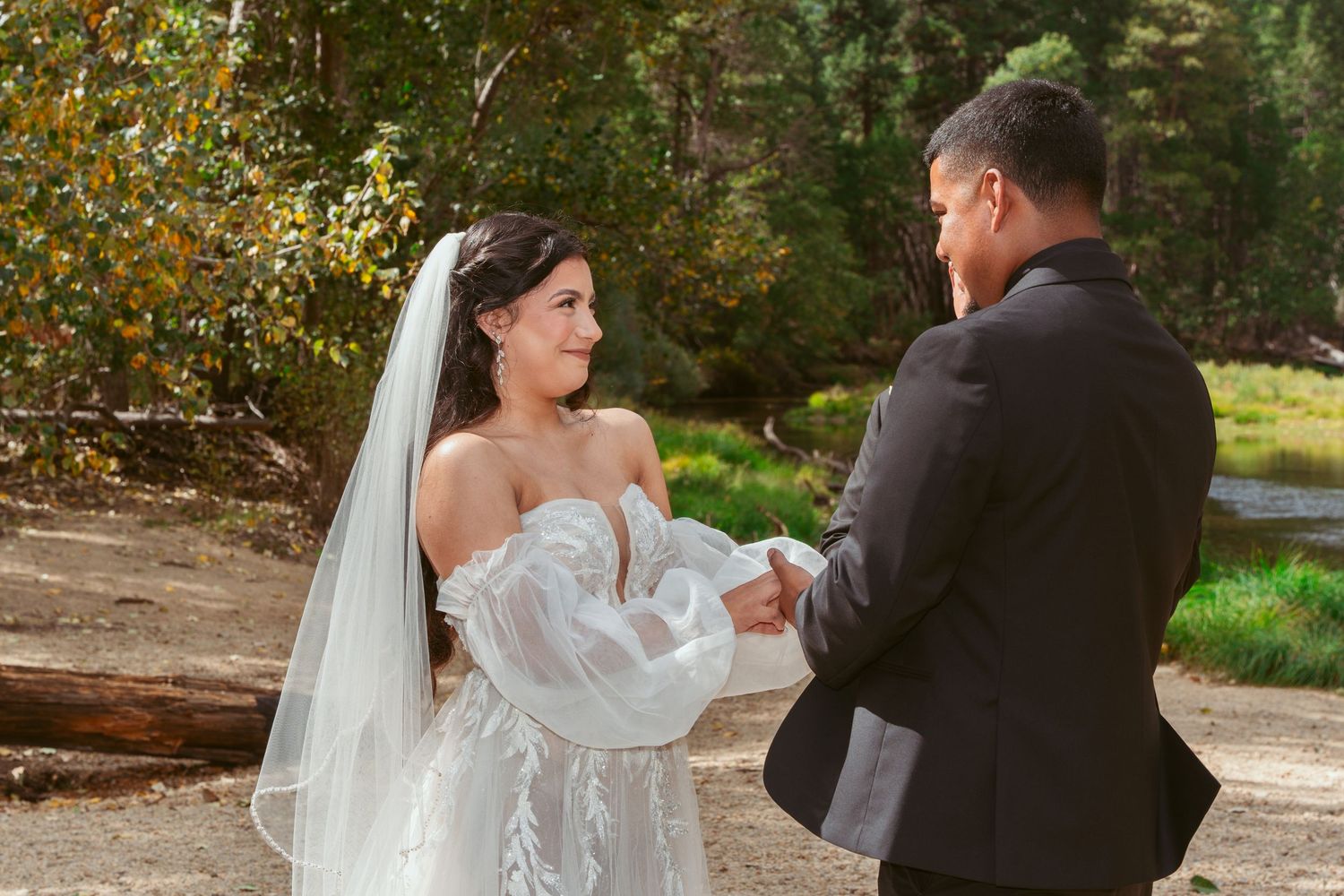 Wedding couple shares first dance outdoors surrounded by fall foliage.