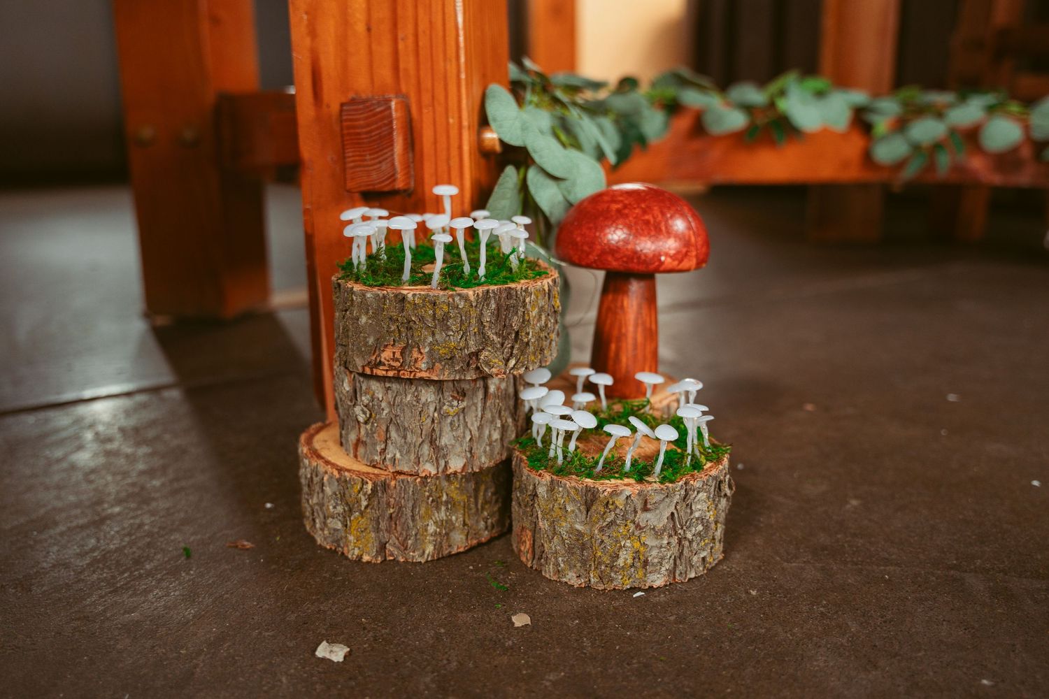 Decorative woodland-themed centerpieces with mushrooms and tree stumps on display.