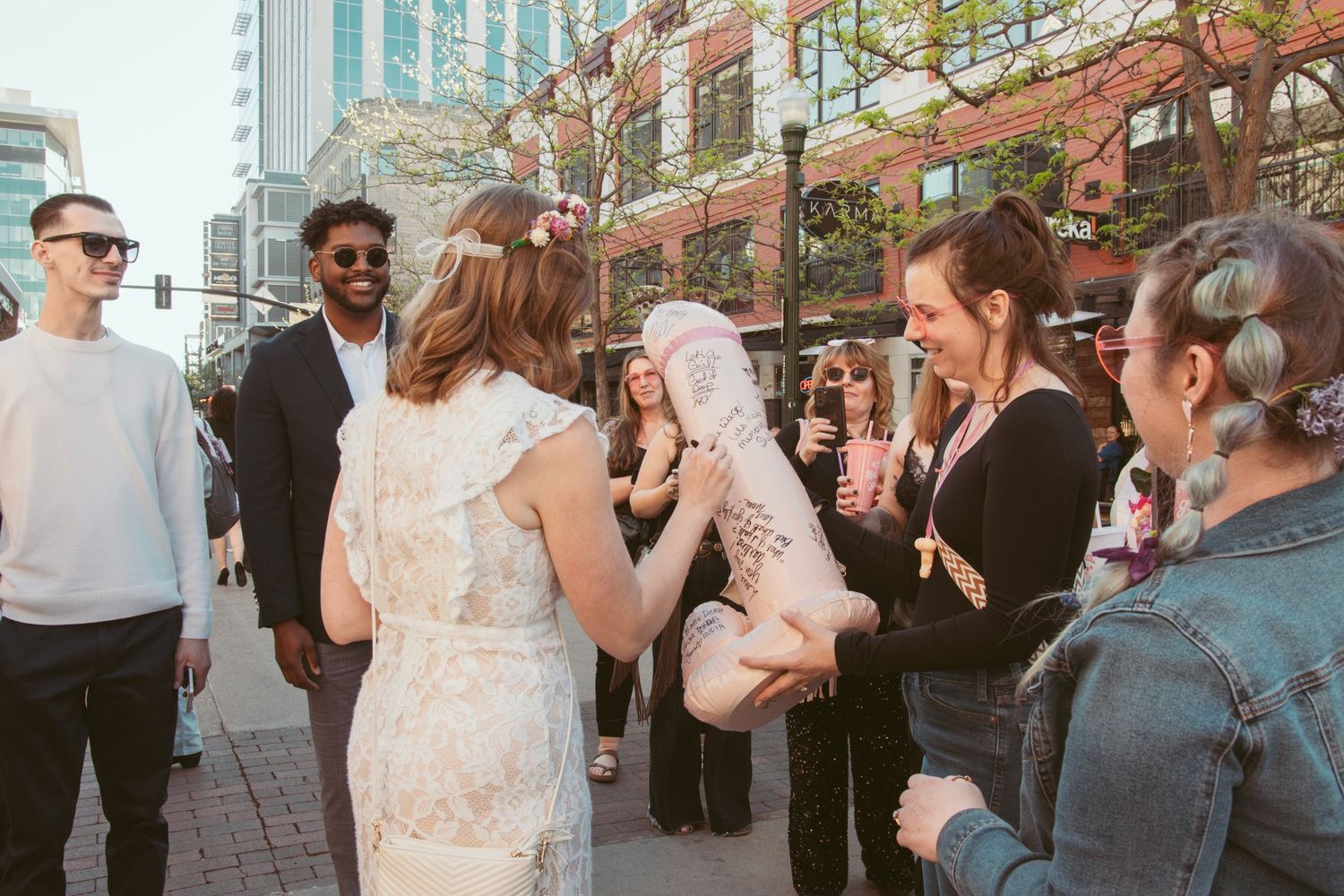 Wedding celebration with guests mingling outdoors in an urban setting.