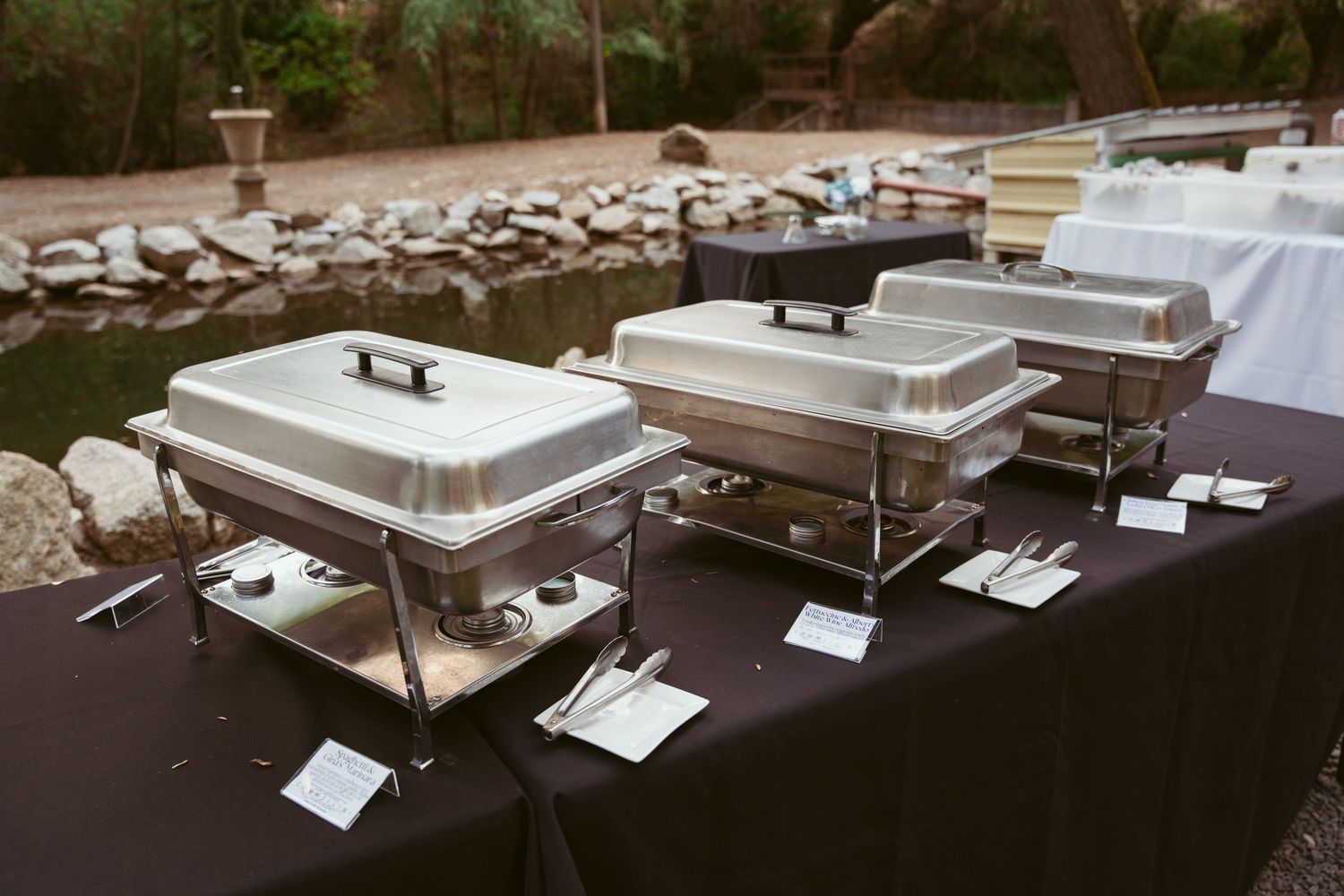 Architectural model display showing multiple white miniature building structures arranged in rows on a dark surface.