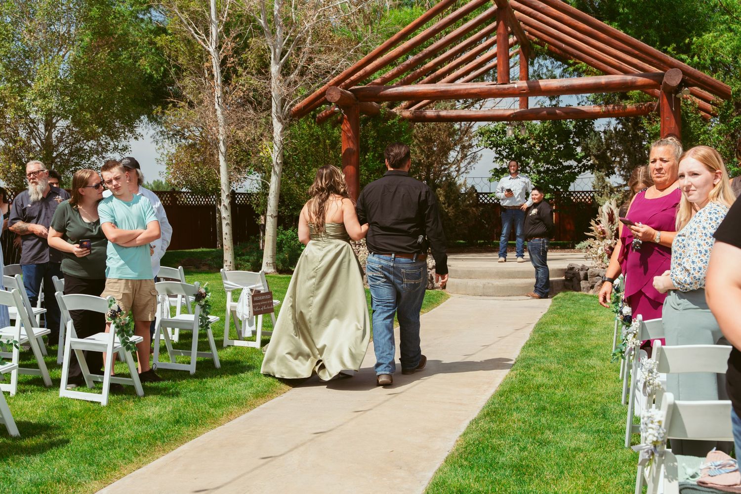 Guests mingle and socialize at an outdoor wedding reception with string lights overhead.