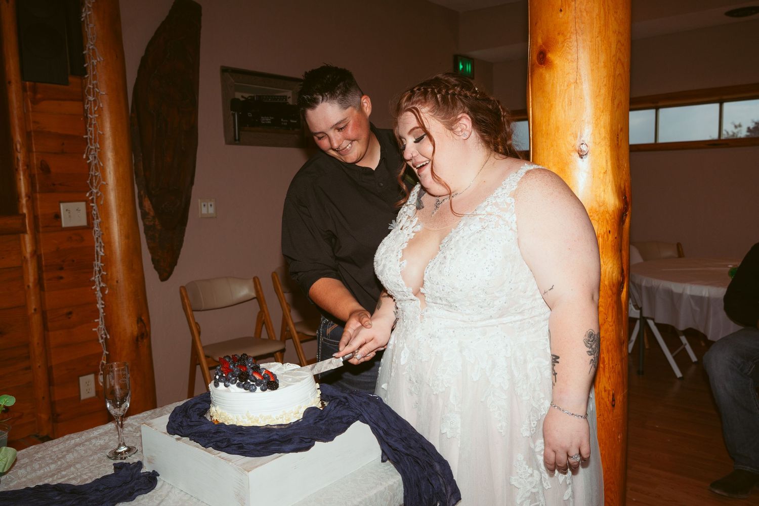 Wedding reception venue with wooden beams and white decor.