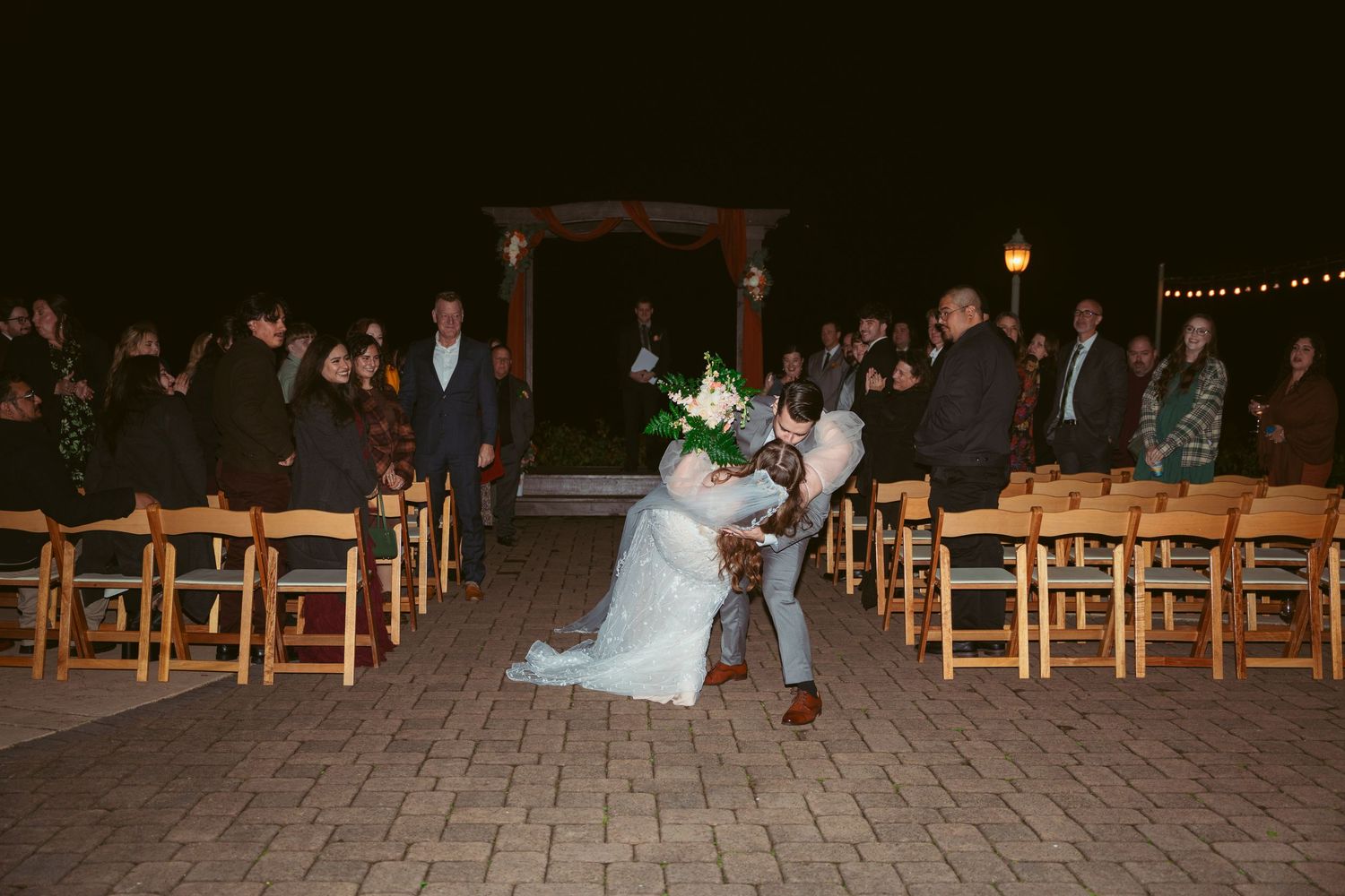 Couple performs a dramatic dip during their wedding ceremony recessional.