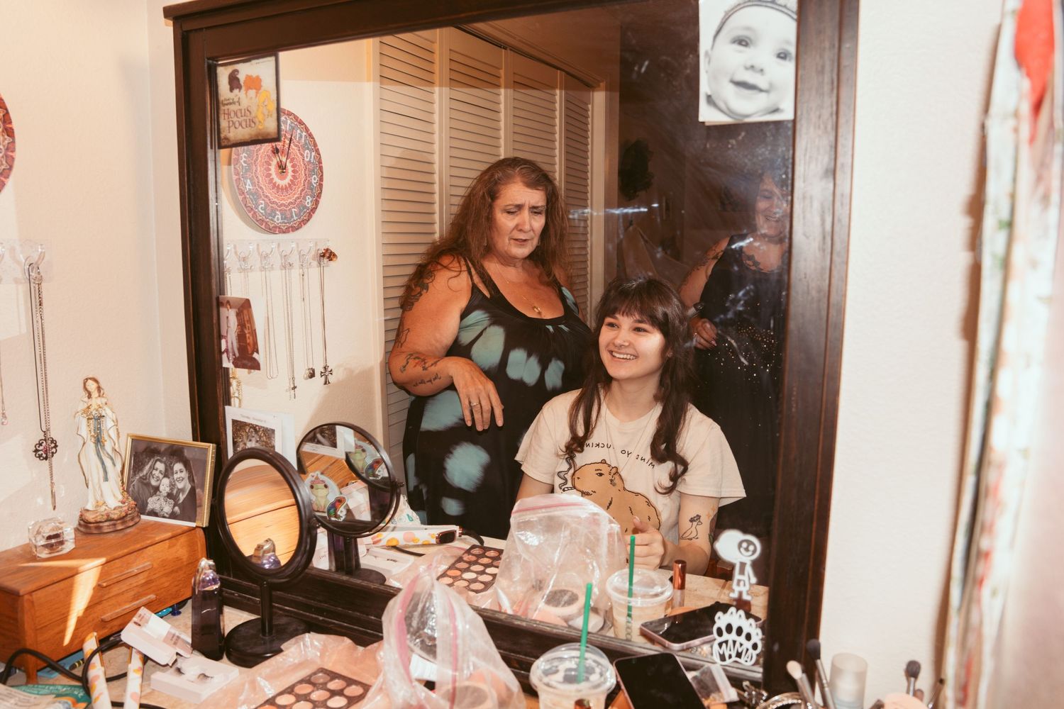 Wedding party getting ready with hair and makeup in a warmly lit room.