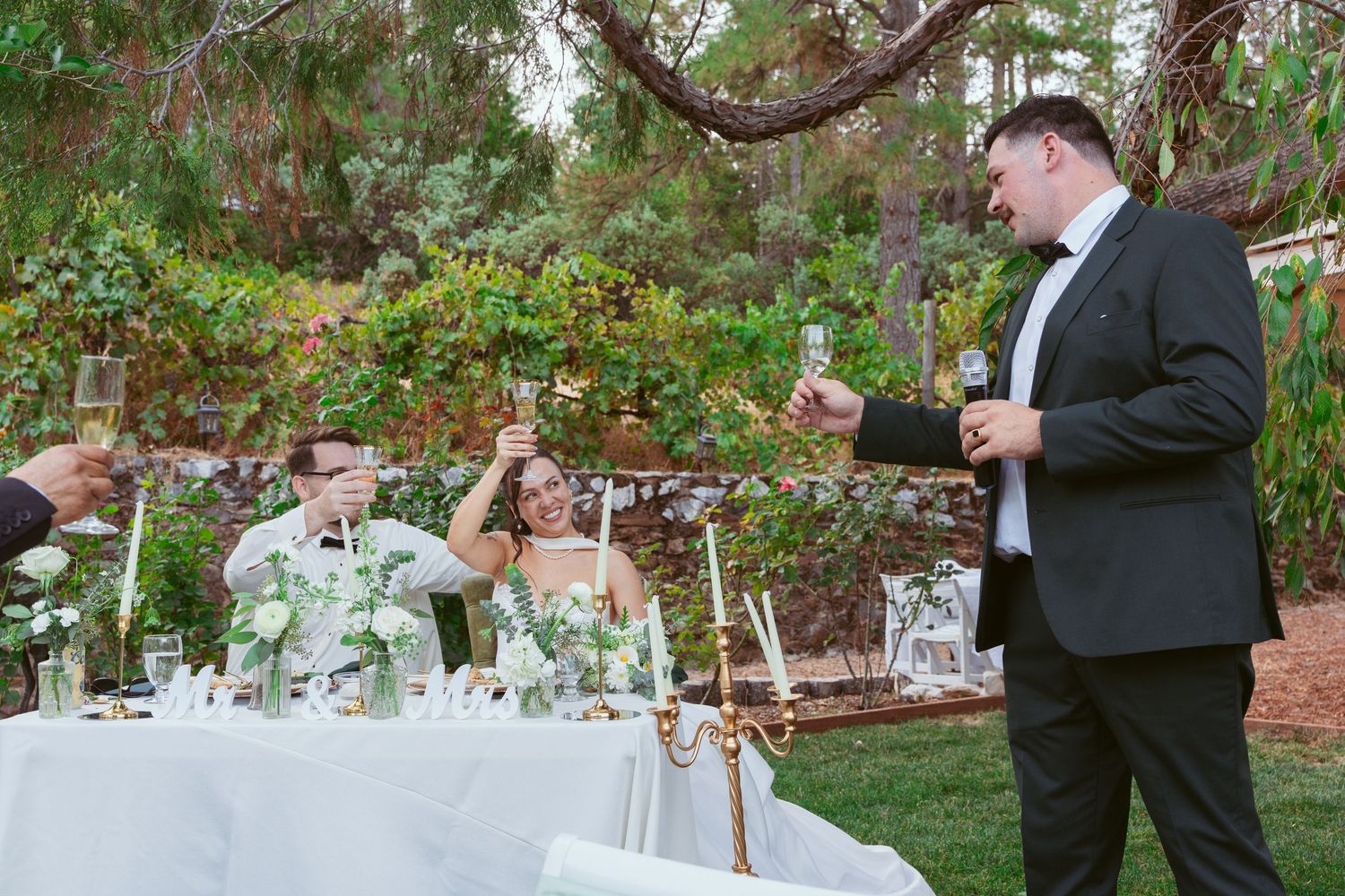 Outdoor wedding reception setup with elegant table settings and floral arrangements.