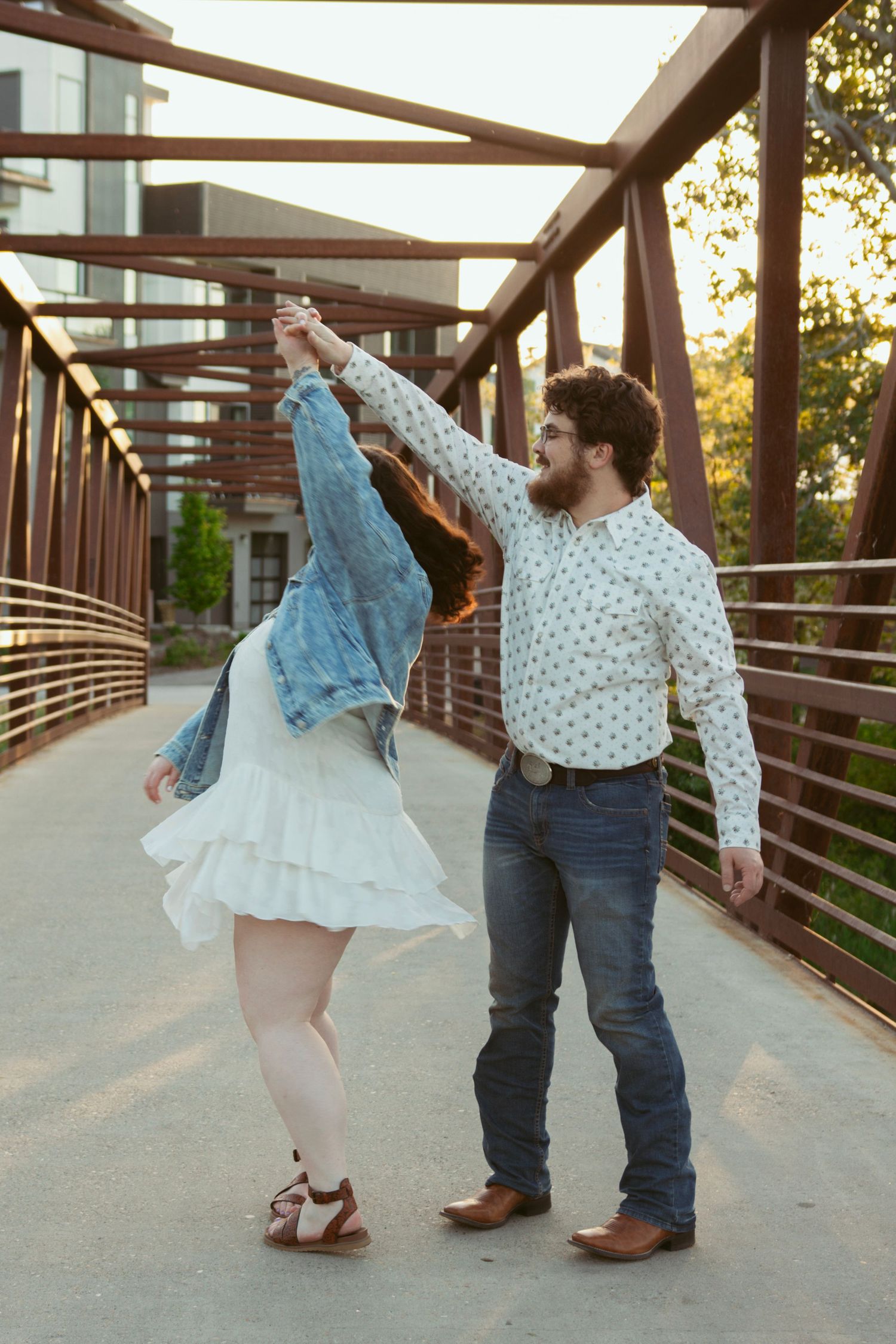 Couple shares a romantic dance moment on a wooden walkway.
