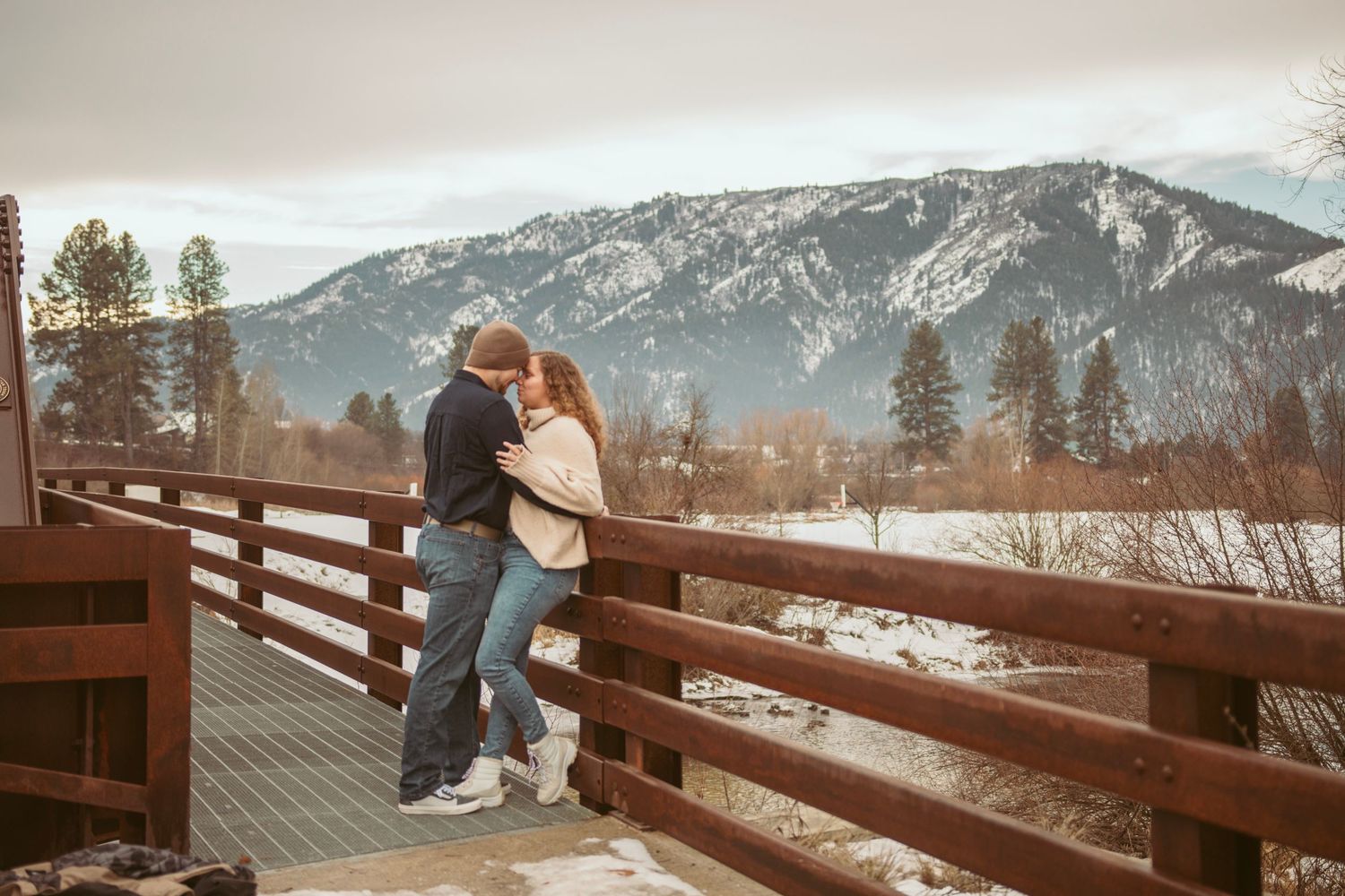 A rustic wooden deck overlooking snow-capped mountains in the distance.