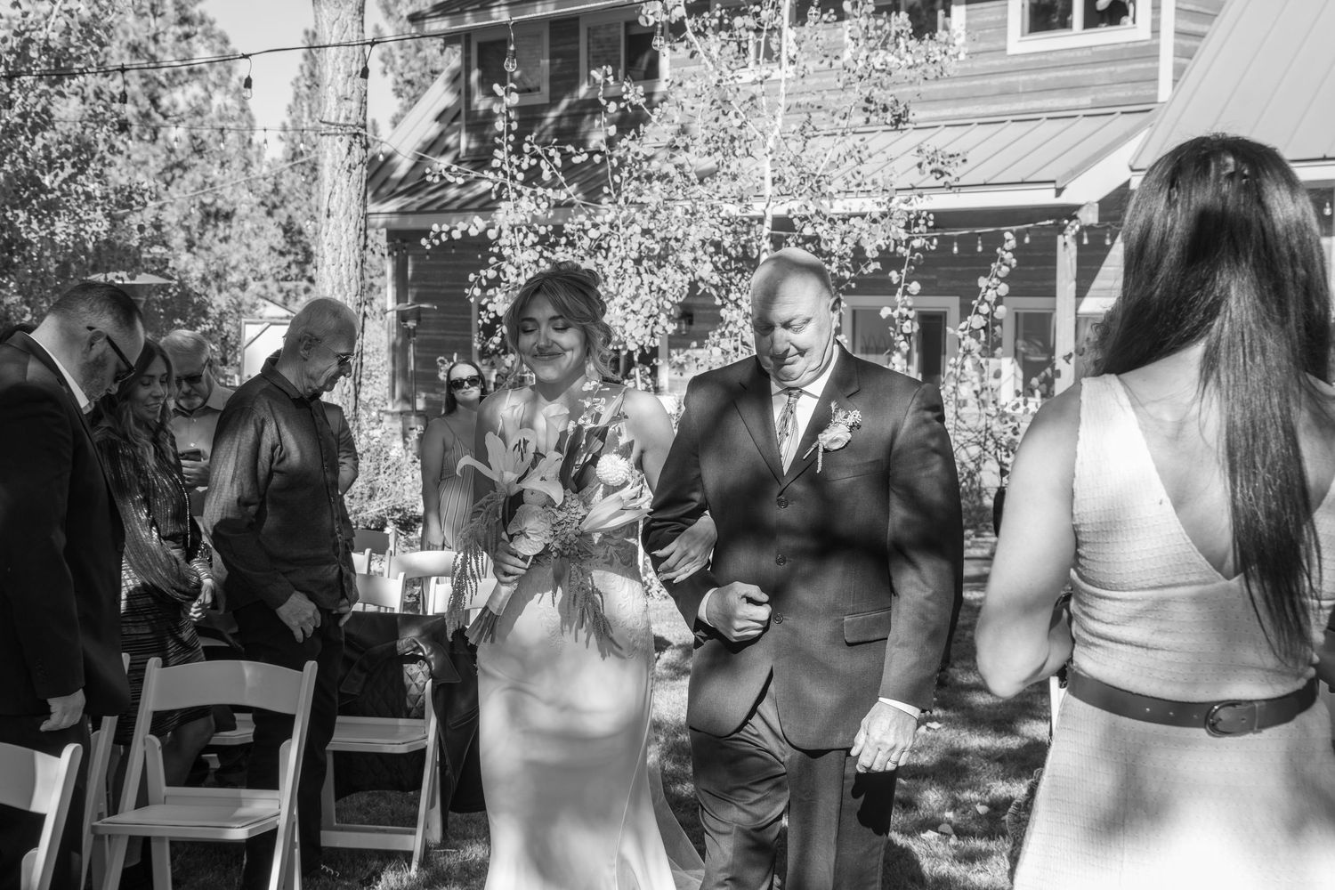 Black and white capture of a wedding ceremony moment in a garden setting.