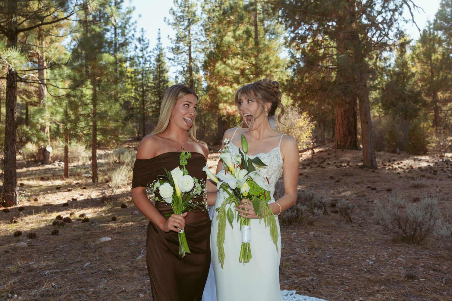 Two people share an intimate moment while holding bouquets in a forest setting.