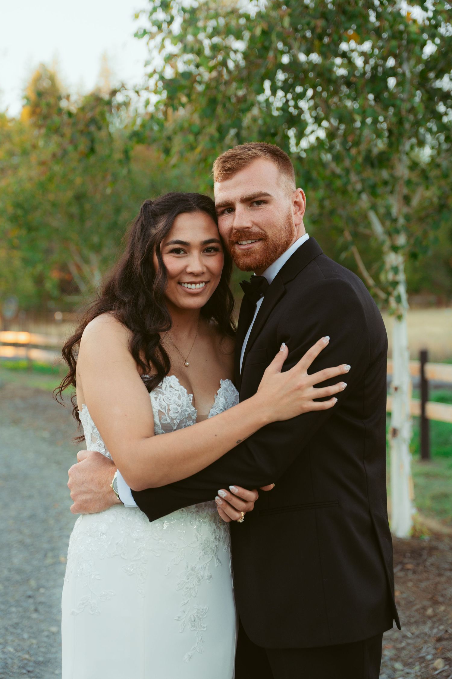 Joyful wedding couple sharing intimate moments and laughter in an outdoor setting.