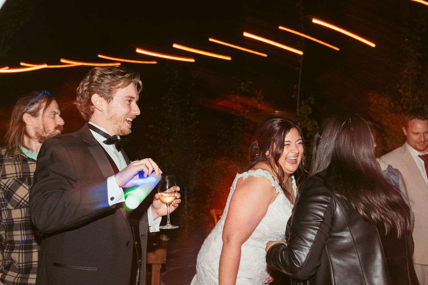 Party guests celebrate on the dance floor with glowing LED accessories.