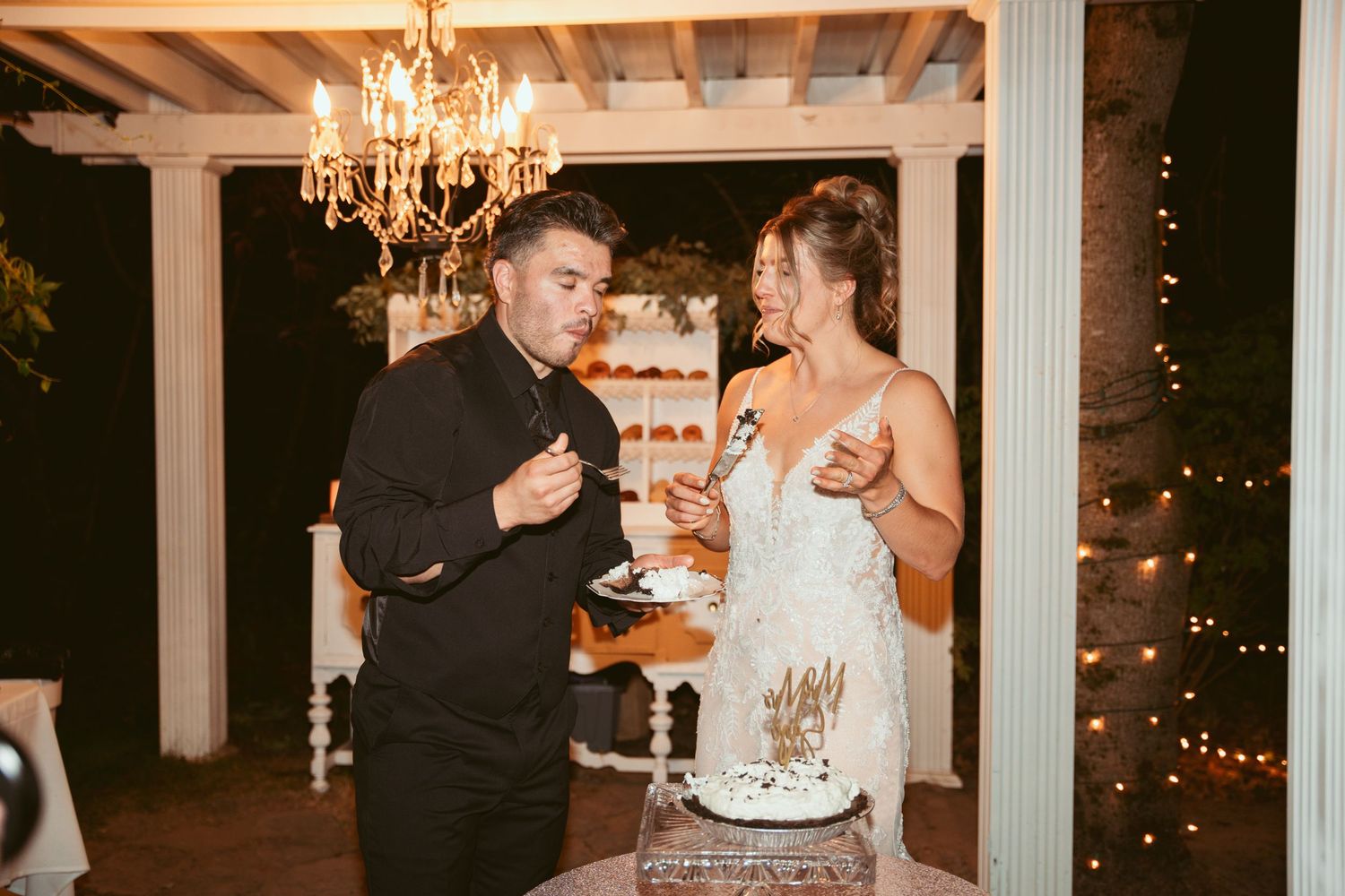 Wedding reception dance floor with elegant chandelier lighting and white columns.