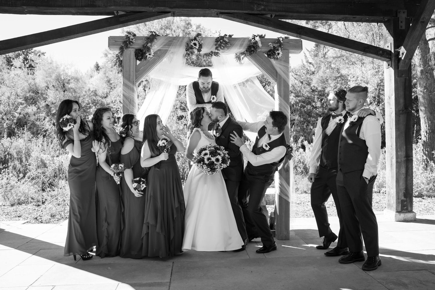 Black and white wedding party group photos showing joyful celebration outdoors.