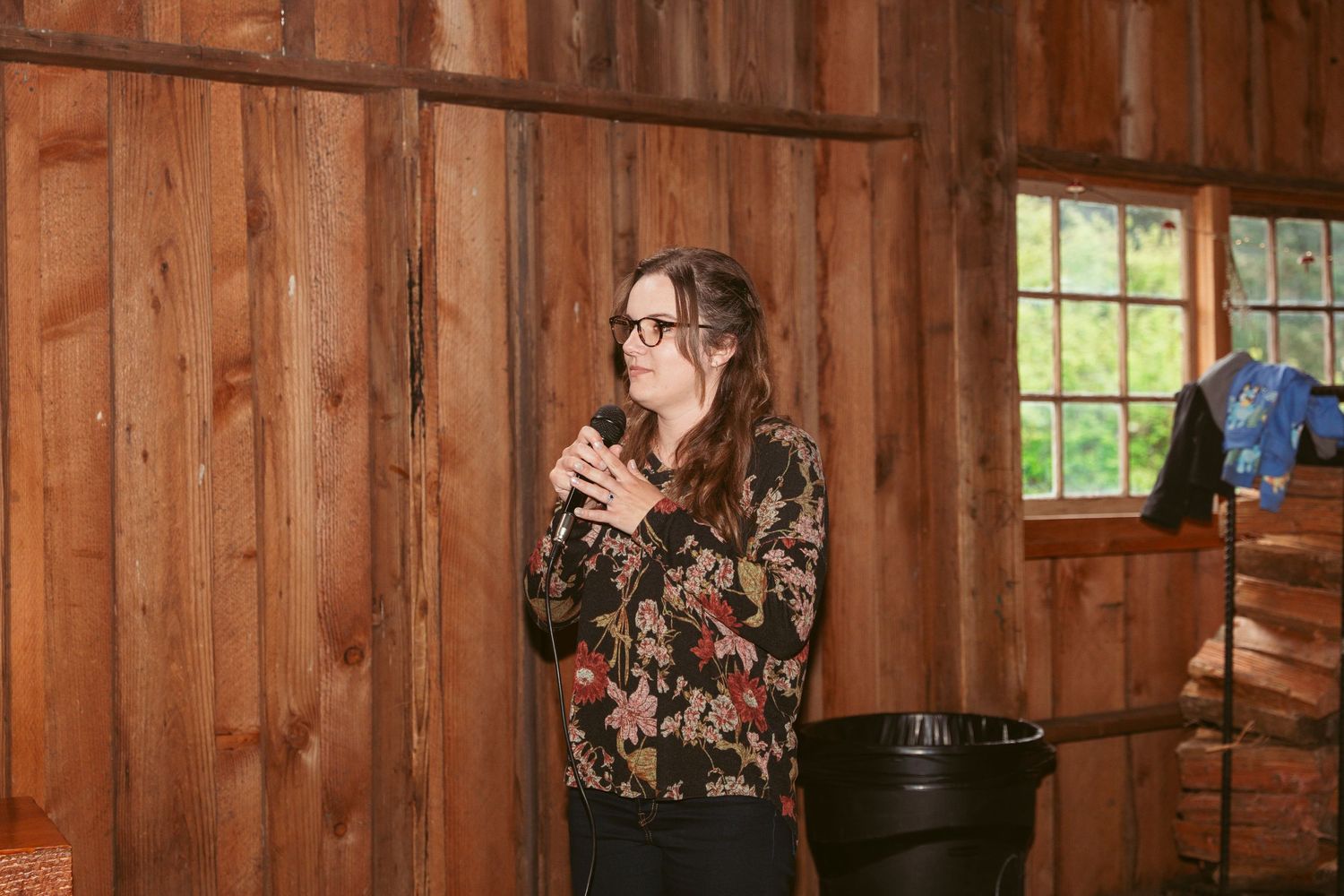 Guests enjoying festivities inside a wooden barn with decorative lighting and rustic decor.
