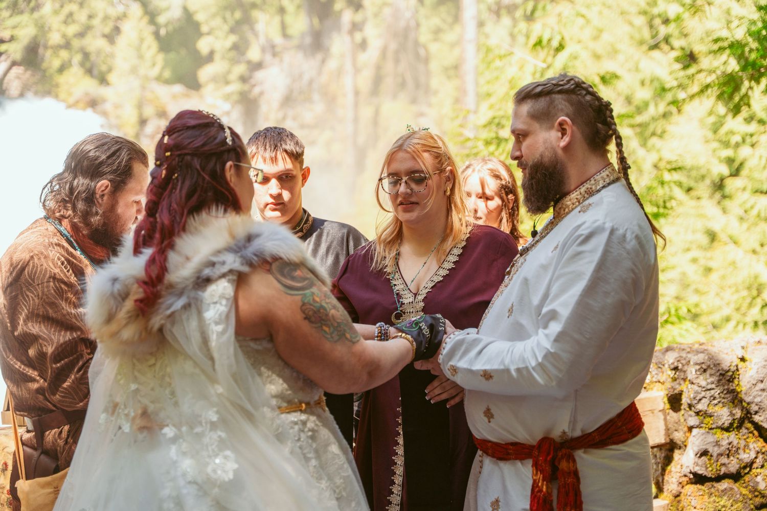 Wedding celebration dance sequence captured in a beautiful forest setting with golden sunlight.