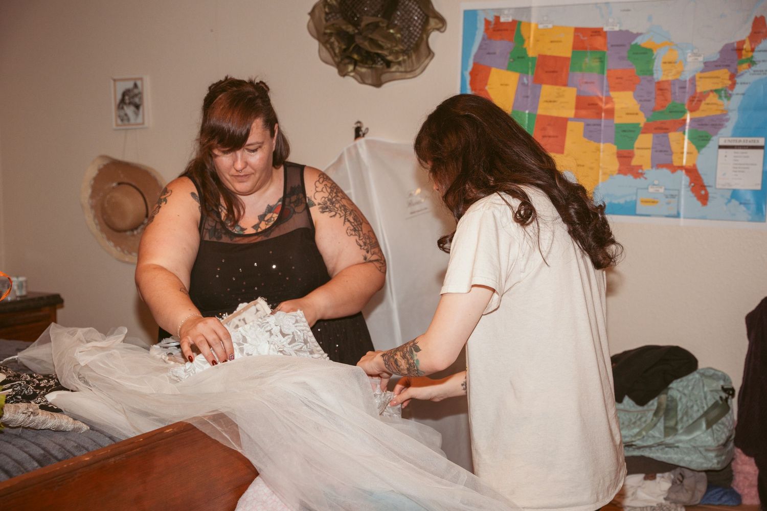 Preparation scene with a white dress being adjusted against a wall with a US map.