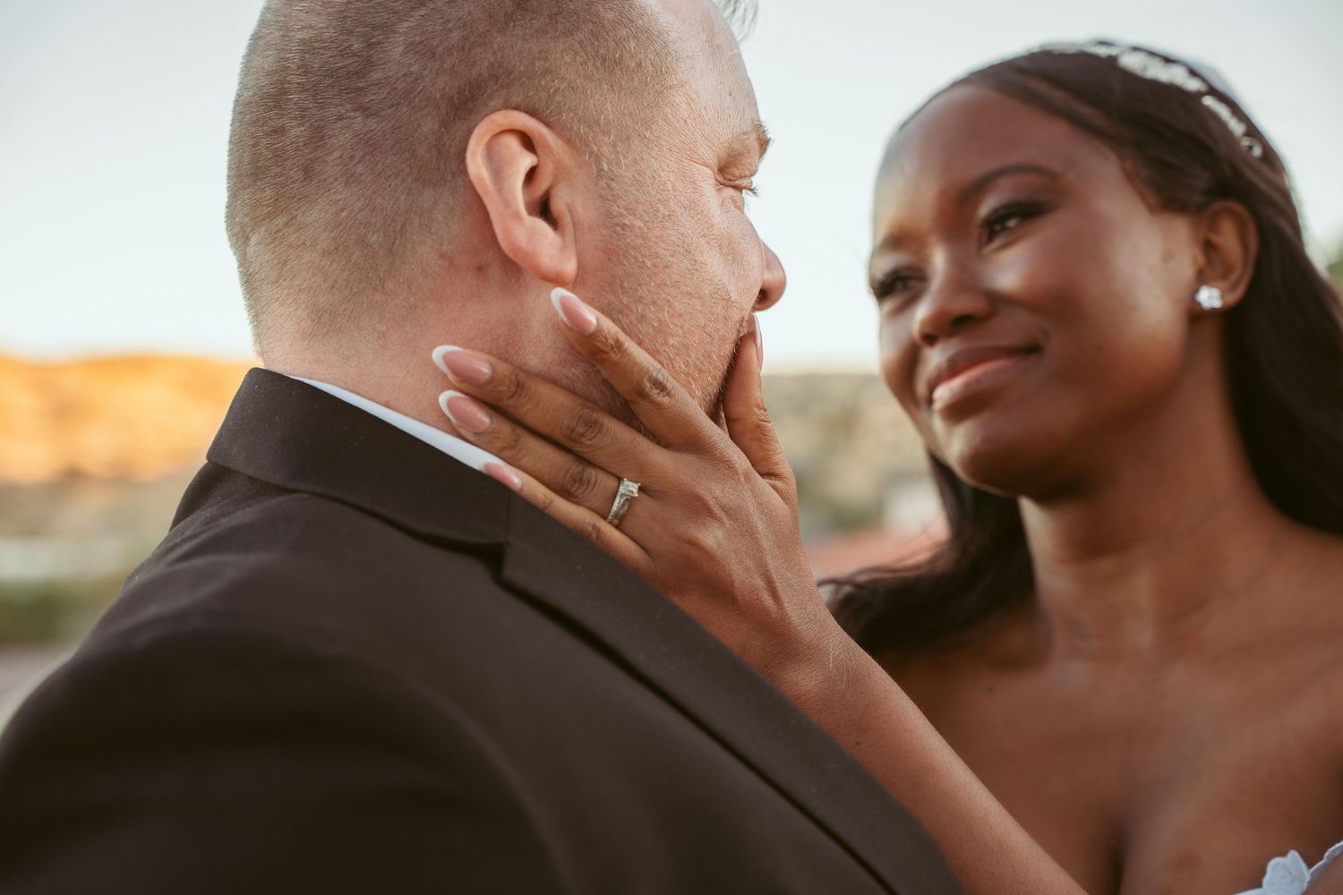 An intimate moment between newlyweds during their desert wedding ceremony.