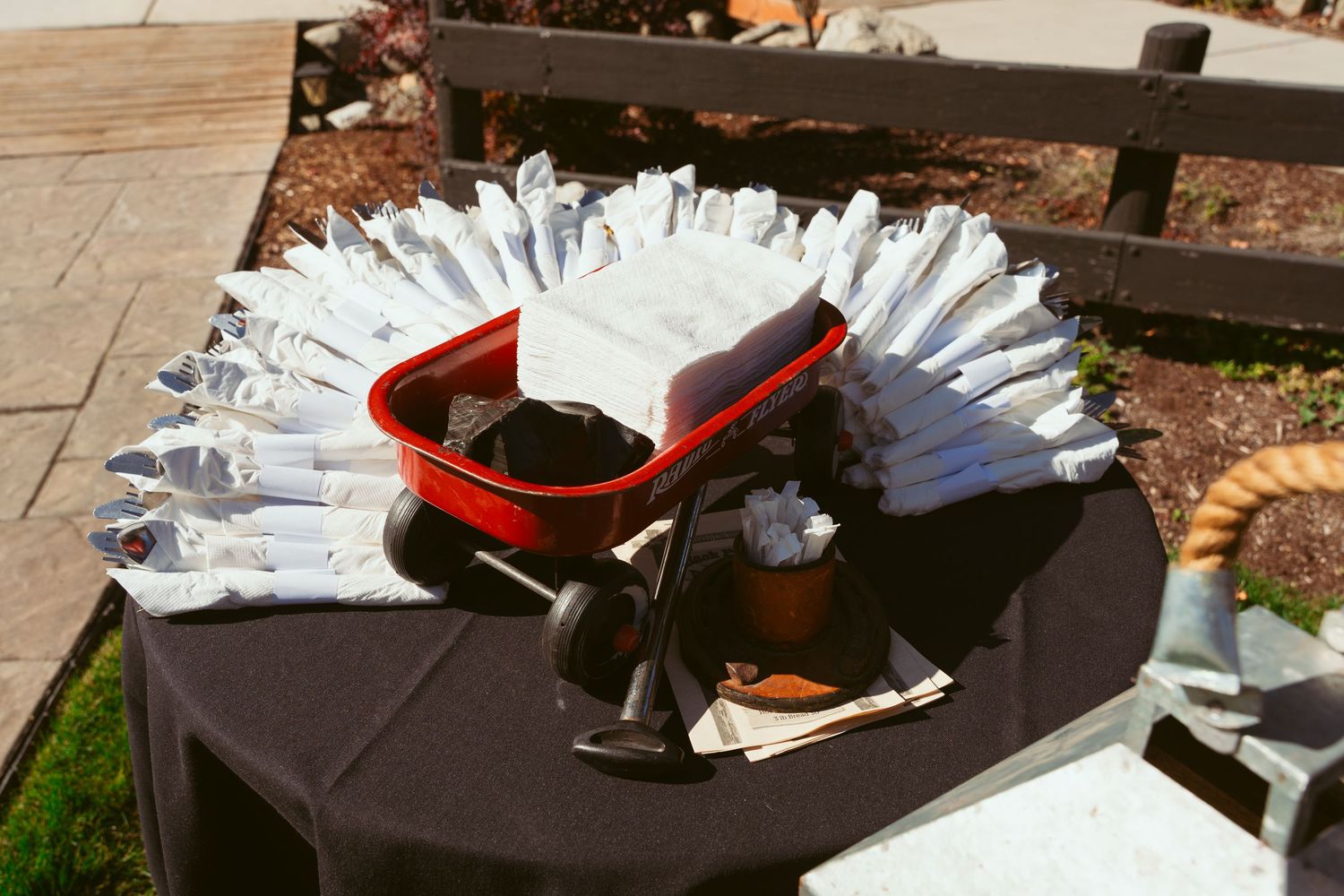Wedding favor display with white paper fans arranged in circular pattern.