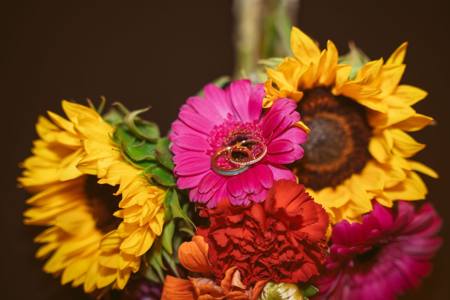 Vibrant sunflowers and pink gerbera daisies arranged in wedding decor.