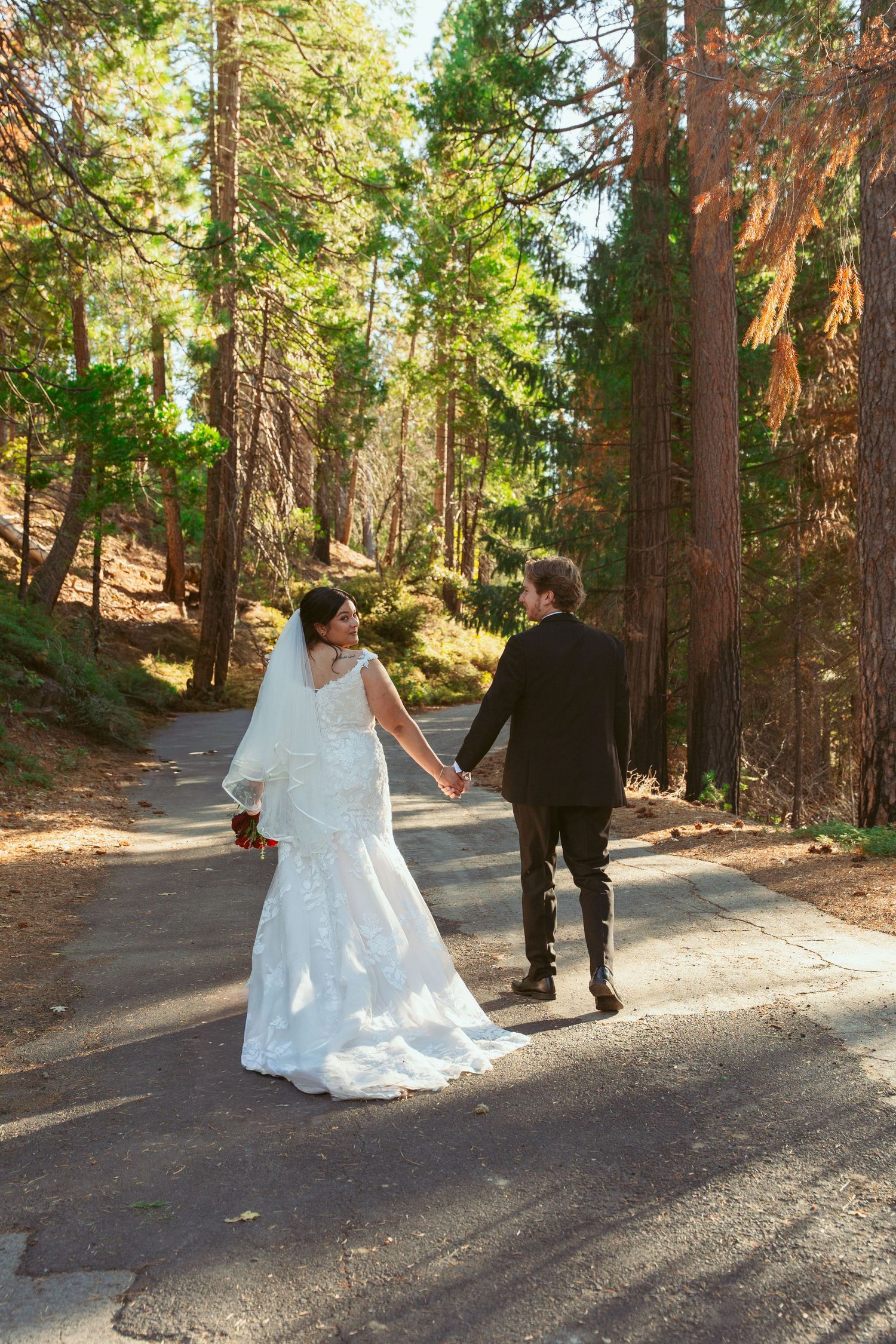 Playful wedding photography sequence captured on a winding forest path.