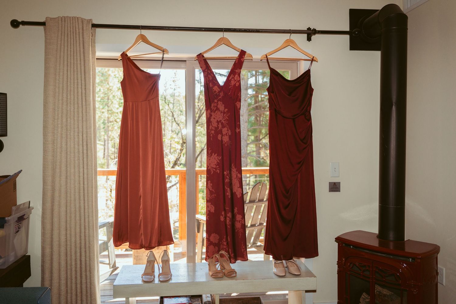 Red and coral colored bridesmaid dresses hanging on display.
