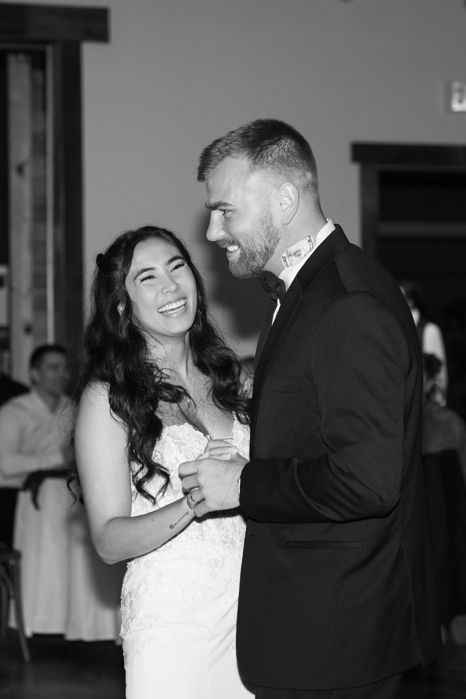 A joyful moment shared during a wedding reception under warm lighting.