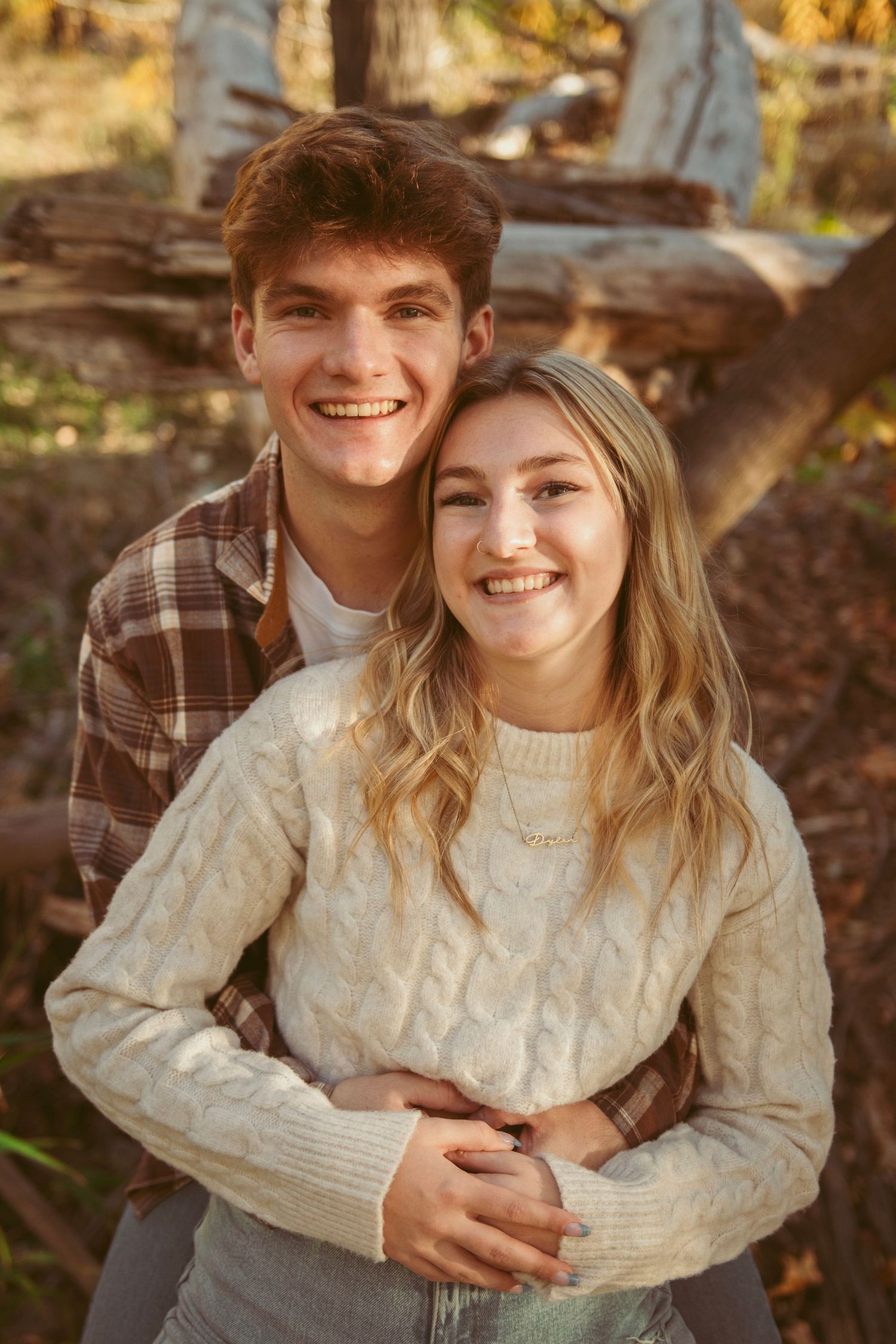 A couple shares a joyful moment together during an autumn photoshoot.