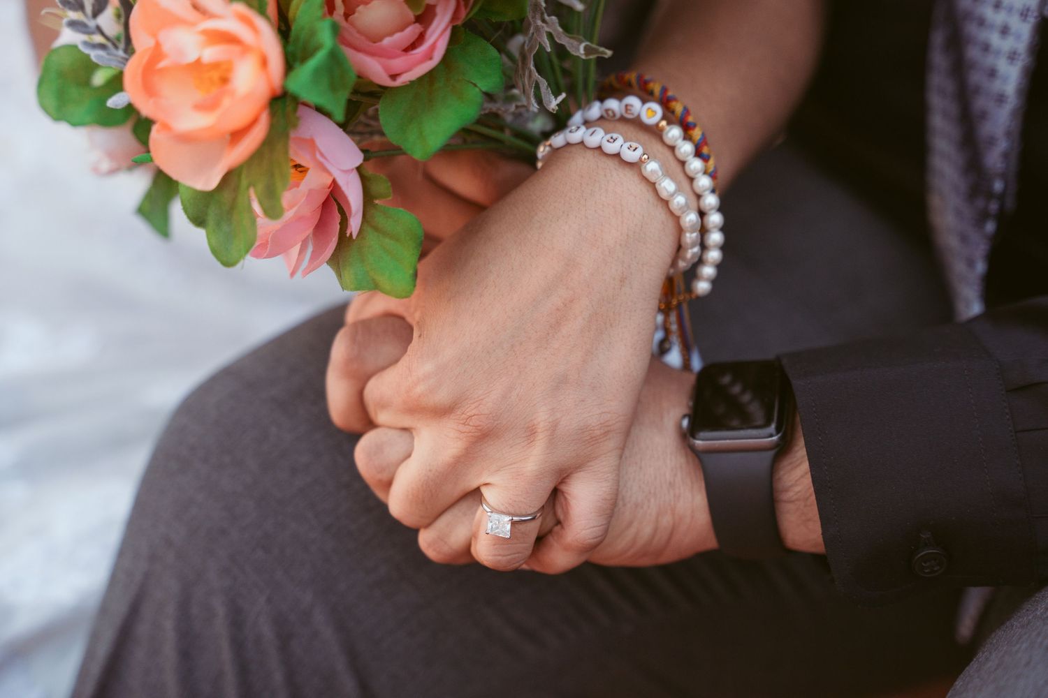 Close-up of wedding bouquet and jewelry details during ceremony.