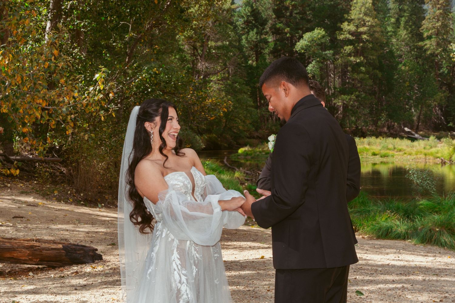 A wedding ceremony takes place in a beautiful autumn forest setting with golden leaves.