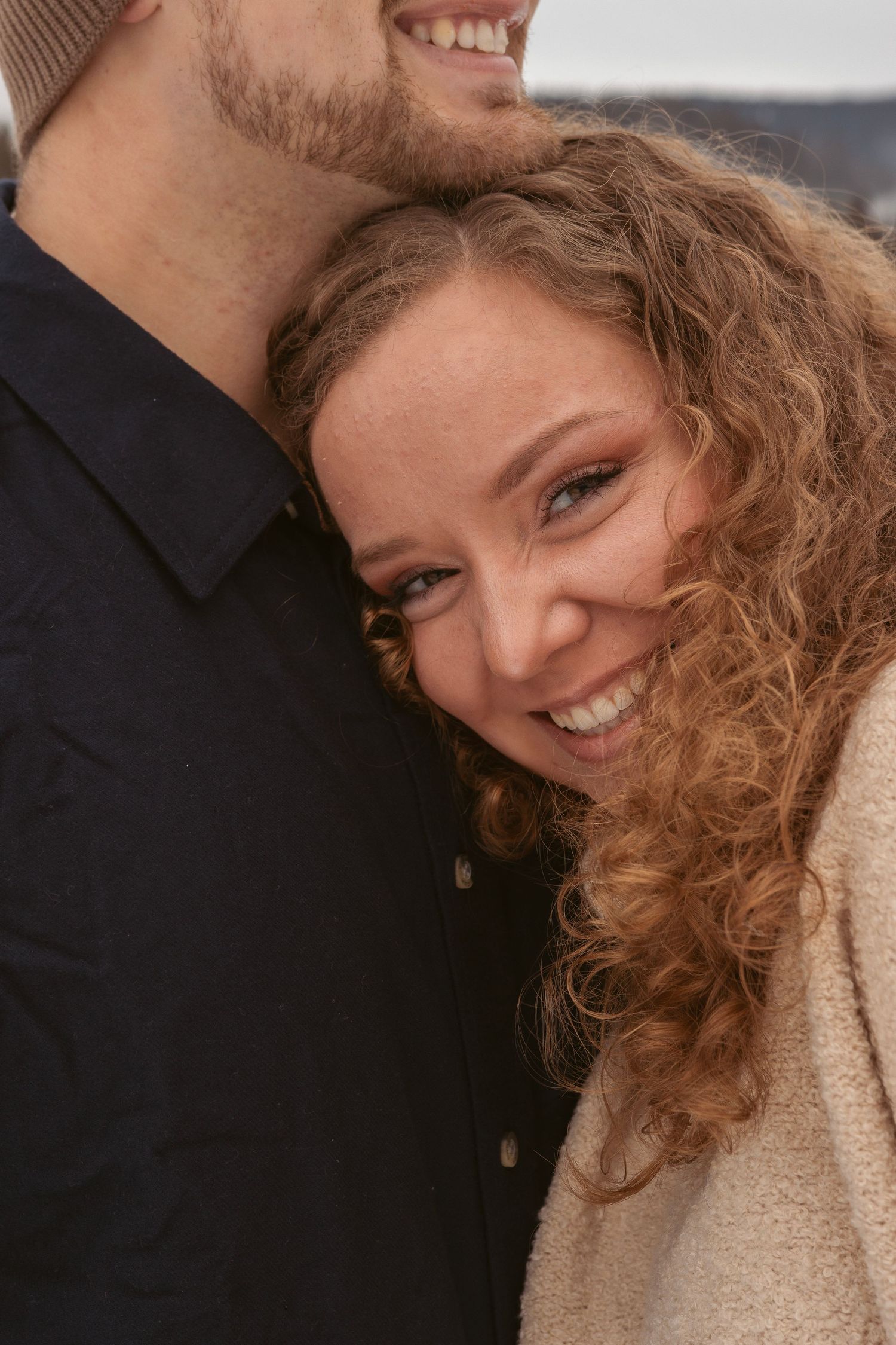 Candid laughter and joy captured in winter engagement photos.