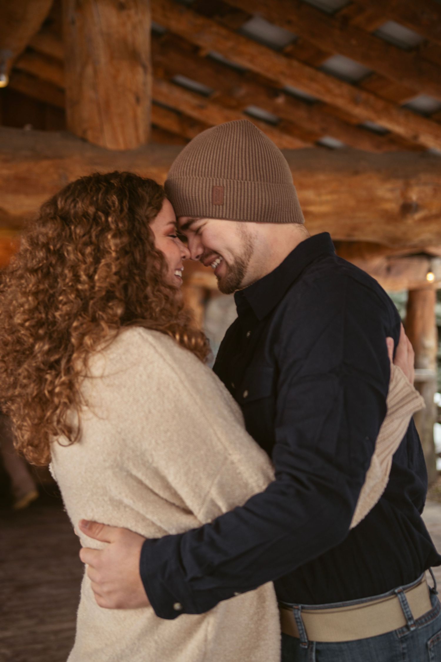 Two people sharing an intimate moment in a rustic wooden interior.