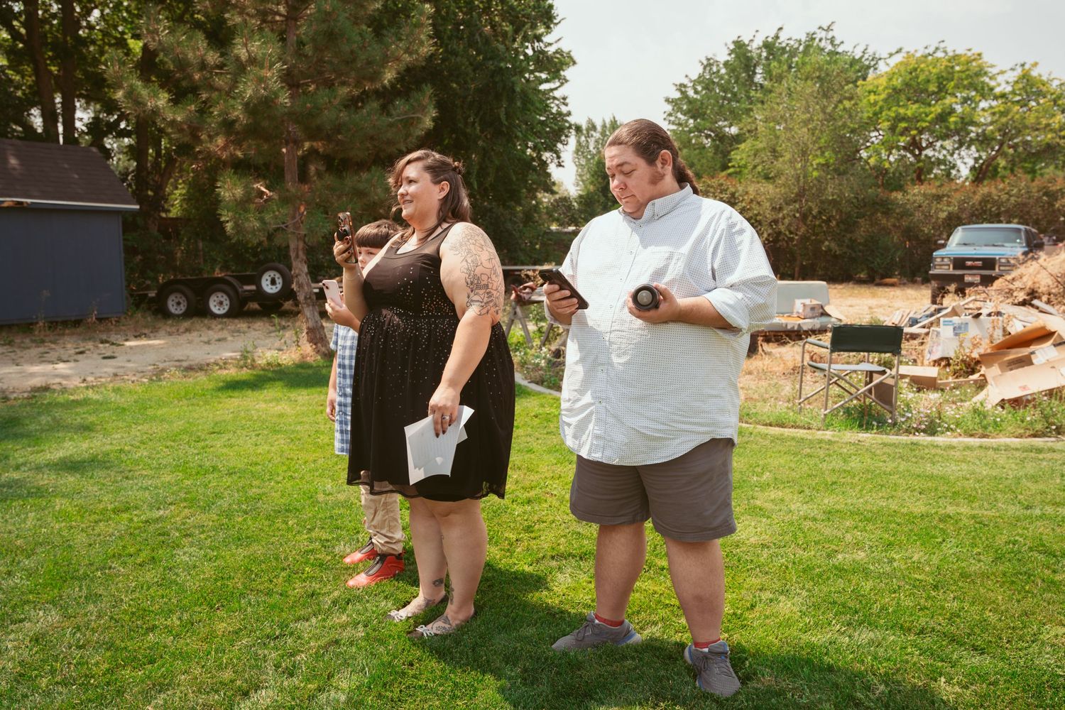 Casual outdoor gathering with guests on a landscaped lawn area.