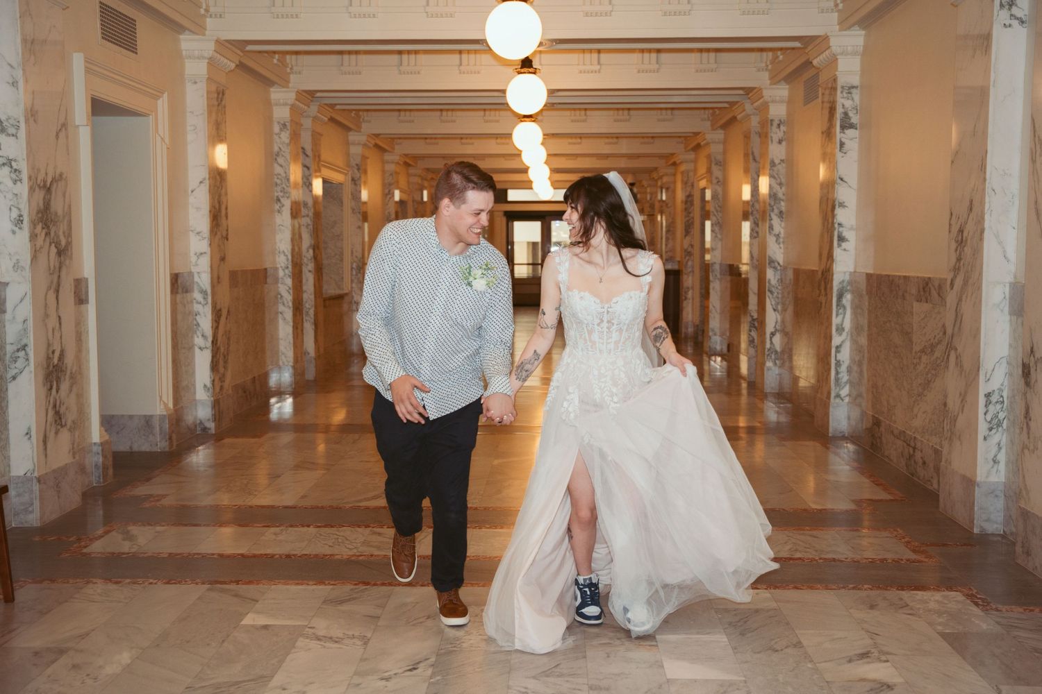 Historic building interior with columns and pendant lights creates romantic wedding atmosphere.