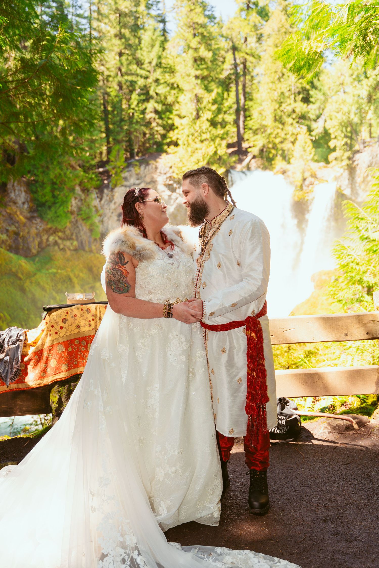 Romantic wedding portraits in a sunlit forest with a medieval-themed couple in traditional attire.