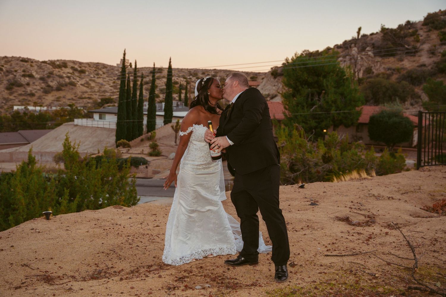 Desert wedding ceremony setup with mountains and cacti in the background during golden hour.