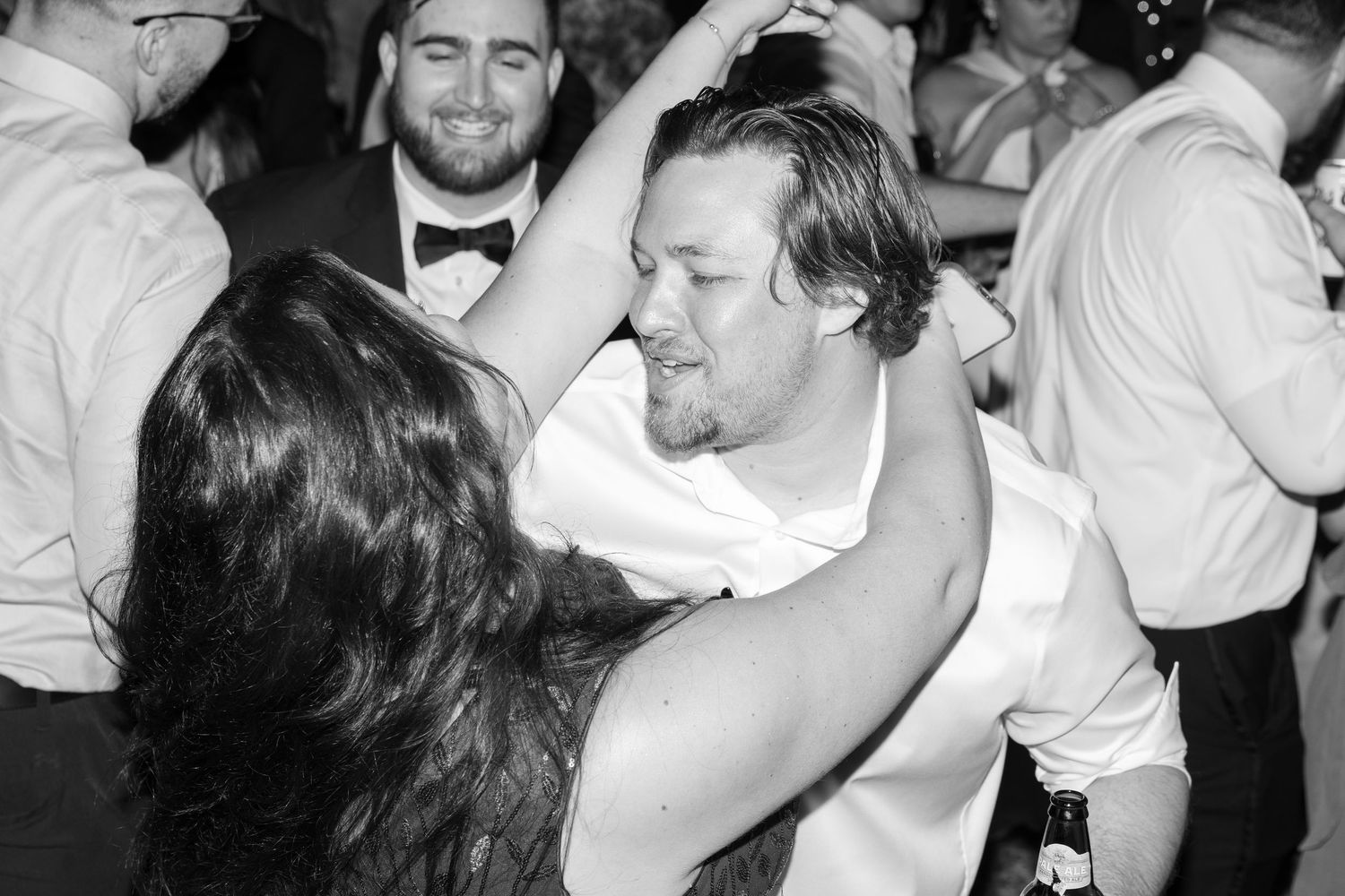 Black and white photos of wedding guests dancing at an evening celebration.