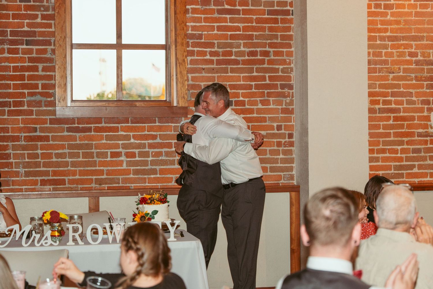Wedding reception space with exposed brick walls and elegant table settings.
