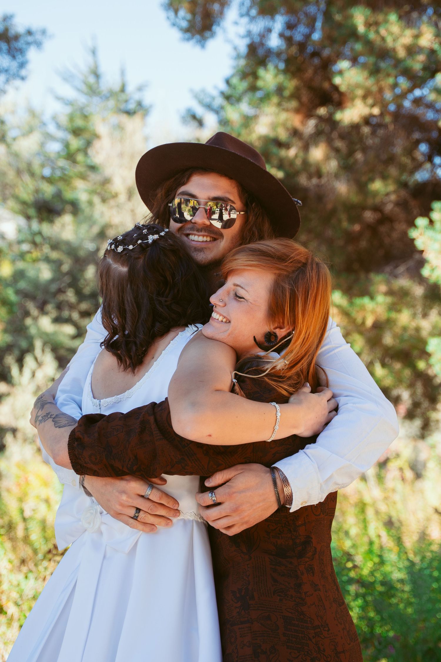 Group sharing emotional embraces during outdoor autumn celebration.