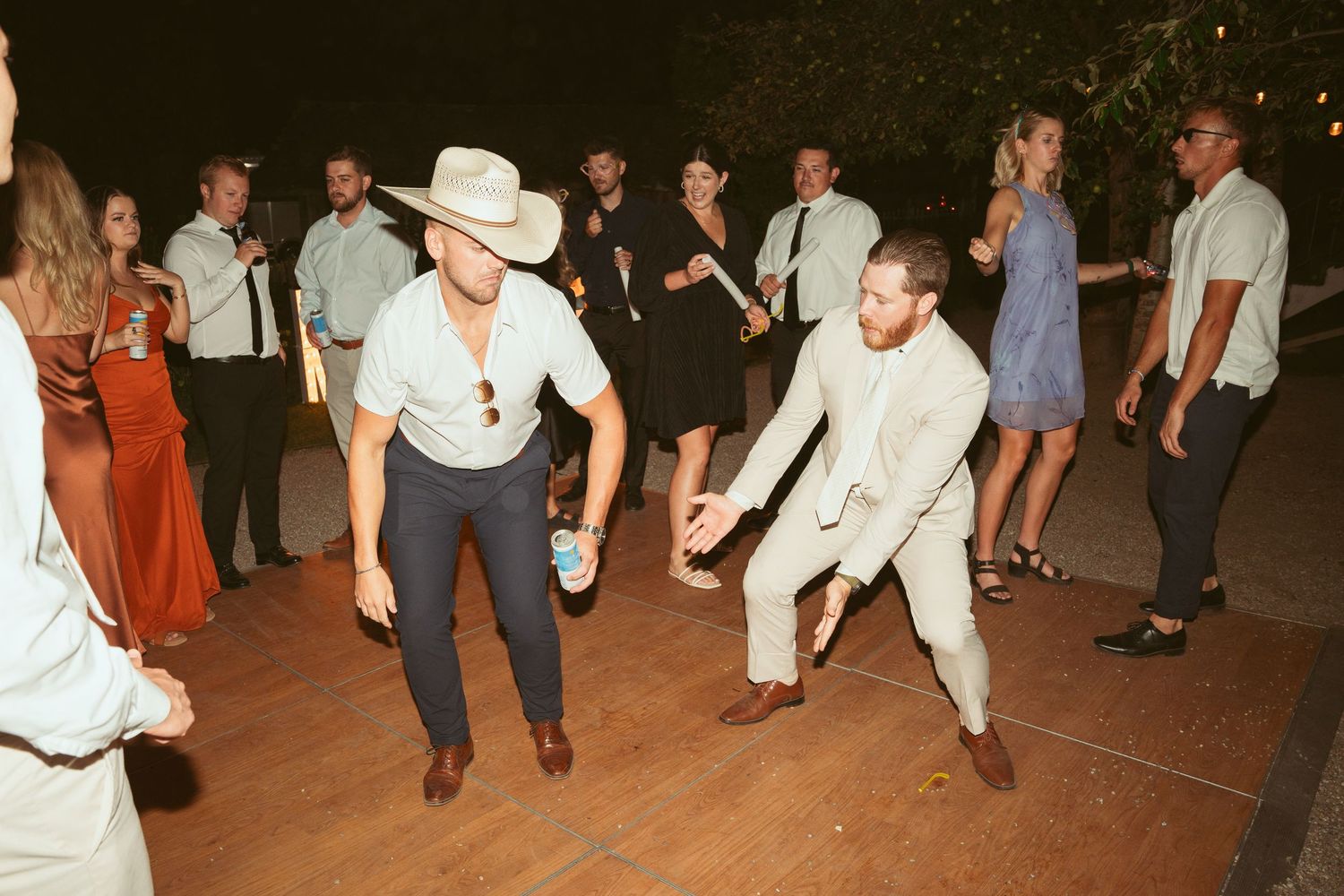 Two guests showing off dance moves at outdoor wedding reception.