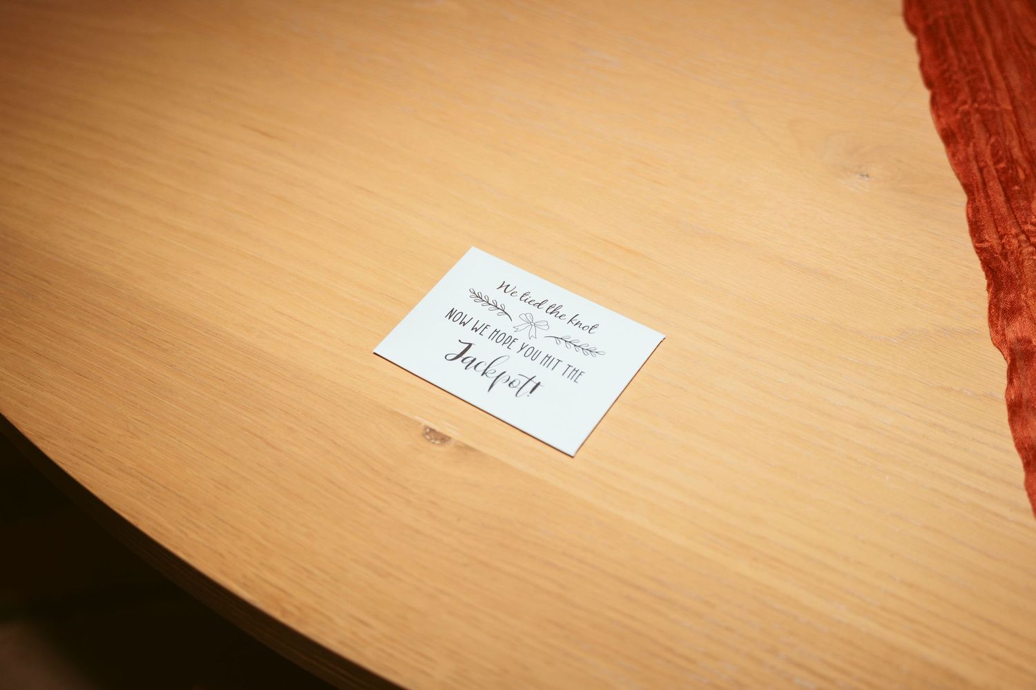Small white note card placed on wooden table surface.