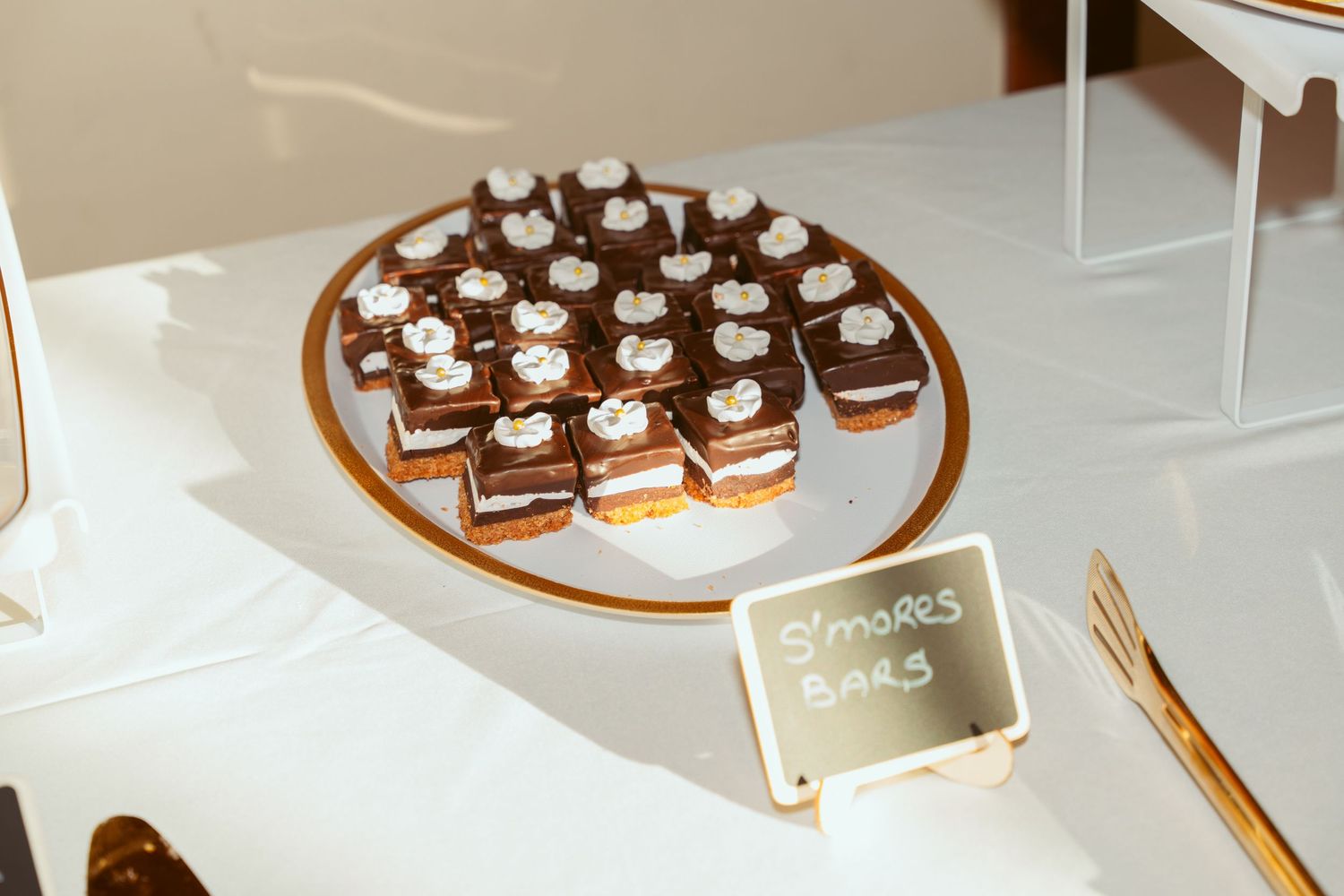 Chocolate desserts arranged on a gold-rimmed platter at a wedding dessert table.