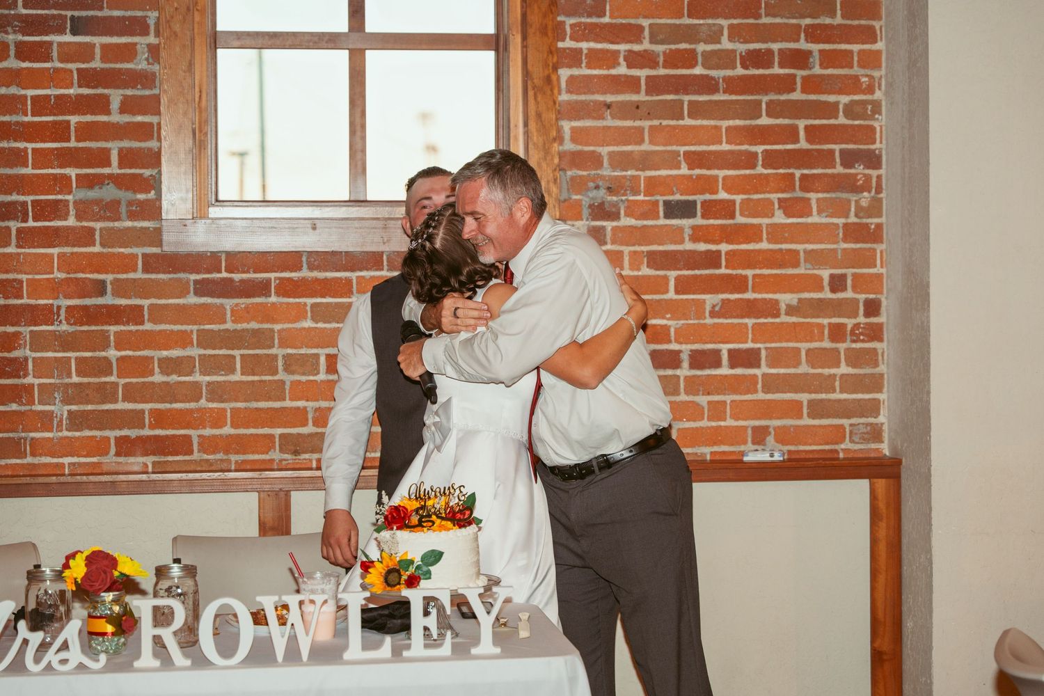 Indoor wedding venue with industrial brick walls and romantic string lighting.