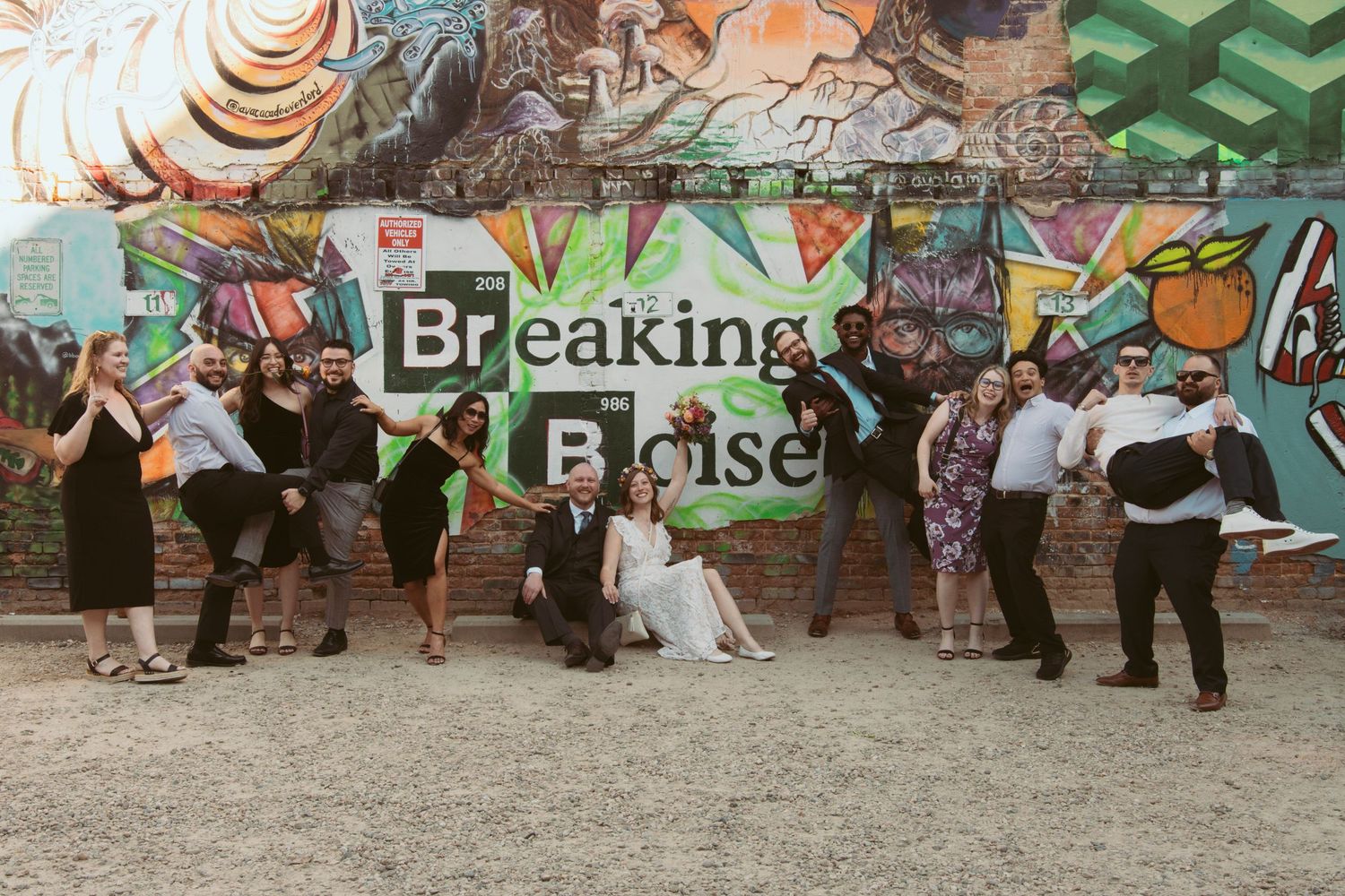 People gathered in front of a colorful graffiti wall at an outdoor event.