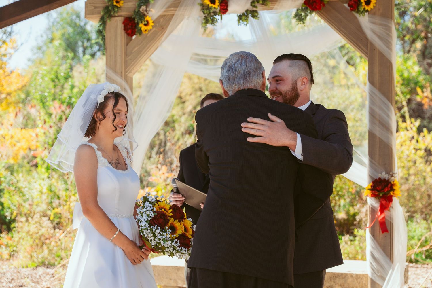 Intimate wedding ceremony moments unfold beneath a stone and wood pavilion.