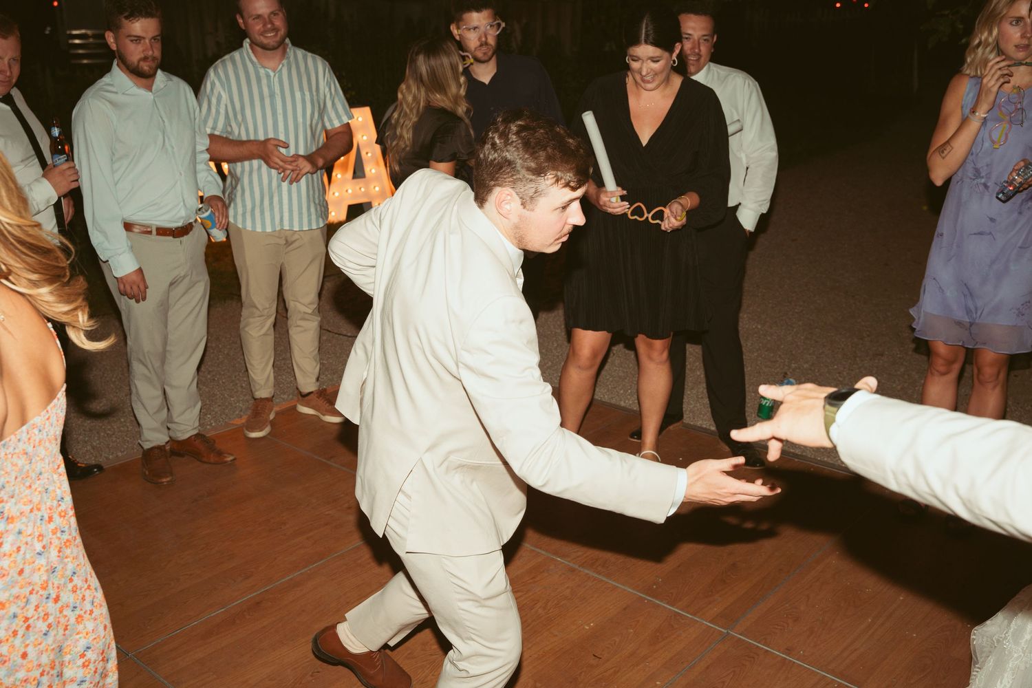 Wedding party members showing off their dance moves at a reception.