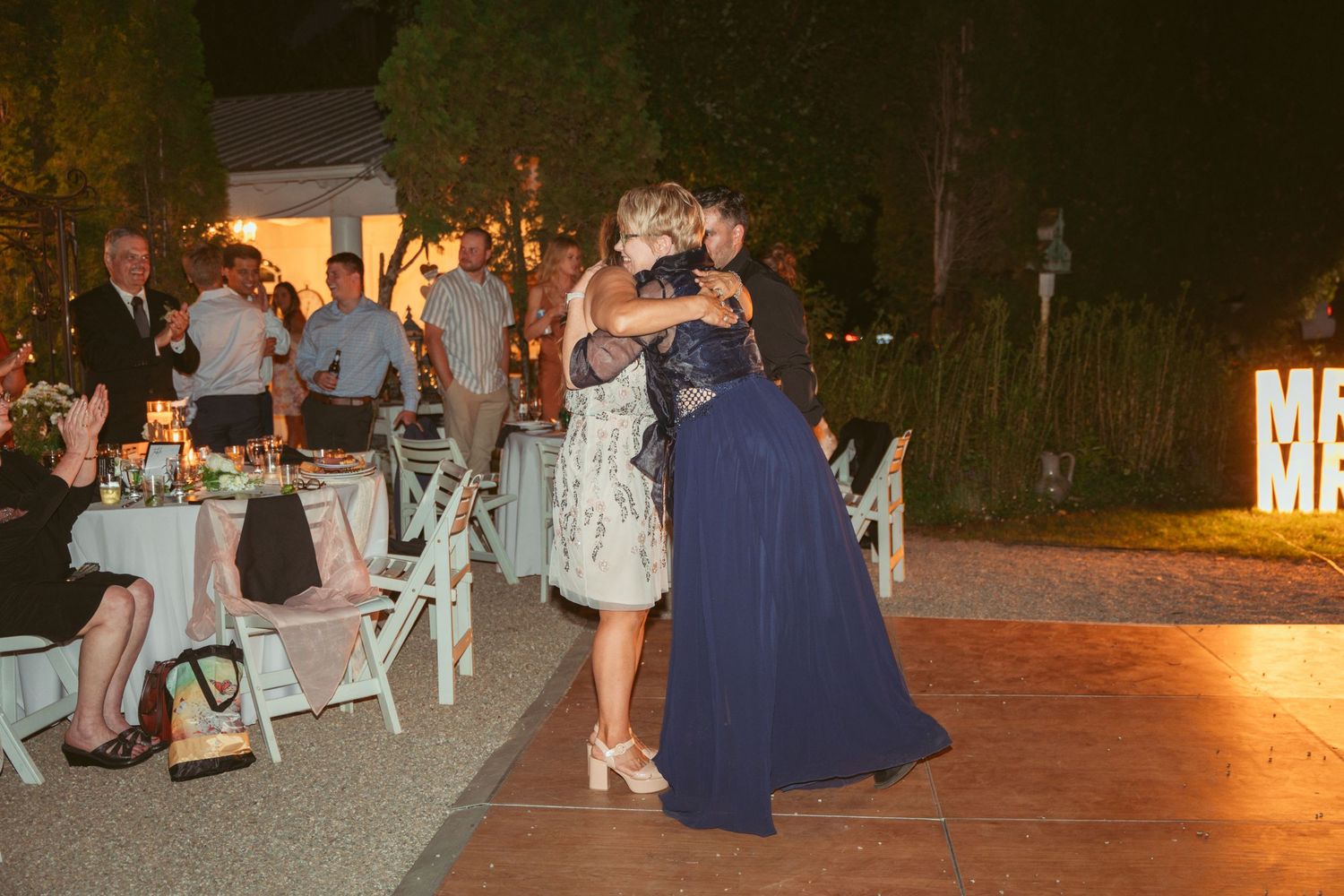 Wedding guests gathered on an outdoor patio for evening celebrations.